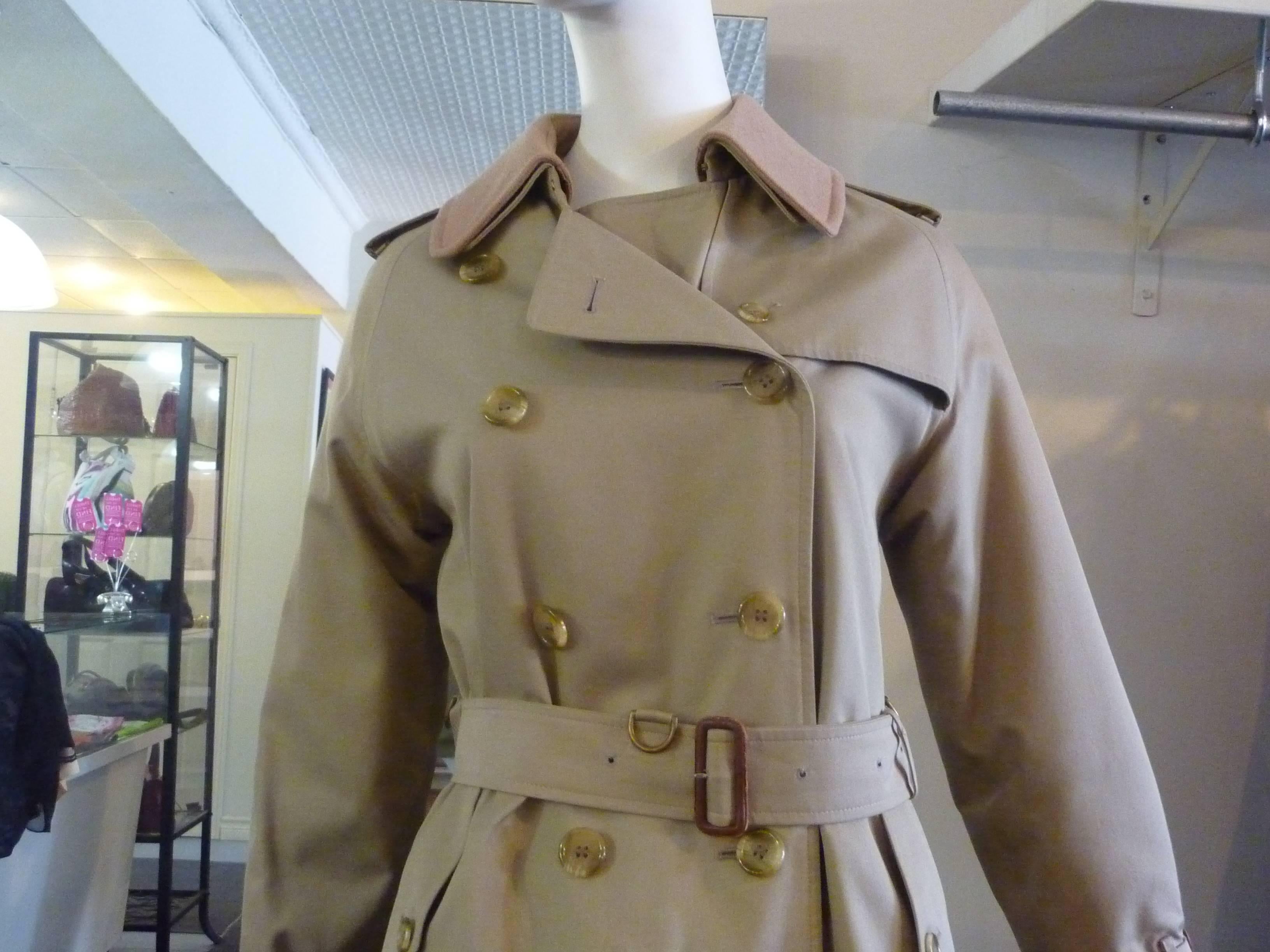Near mint condition, the exception being a couple of marks and two out of the 50 buttons missing. There are two button down side pockets and a pleated feature at the back with a half cape look and epaulettes.

The coat has a removeable wool/camel