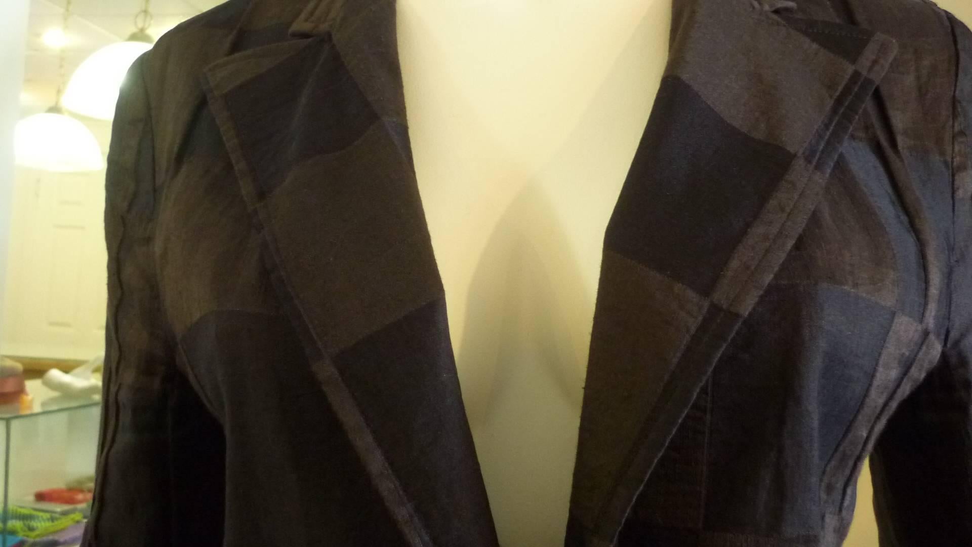 This Dries Van Noten jacket has a nice checkerboard print of brown and black, the jacket/blazer has two front pockets and an interesting one button closure through a leather loop.