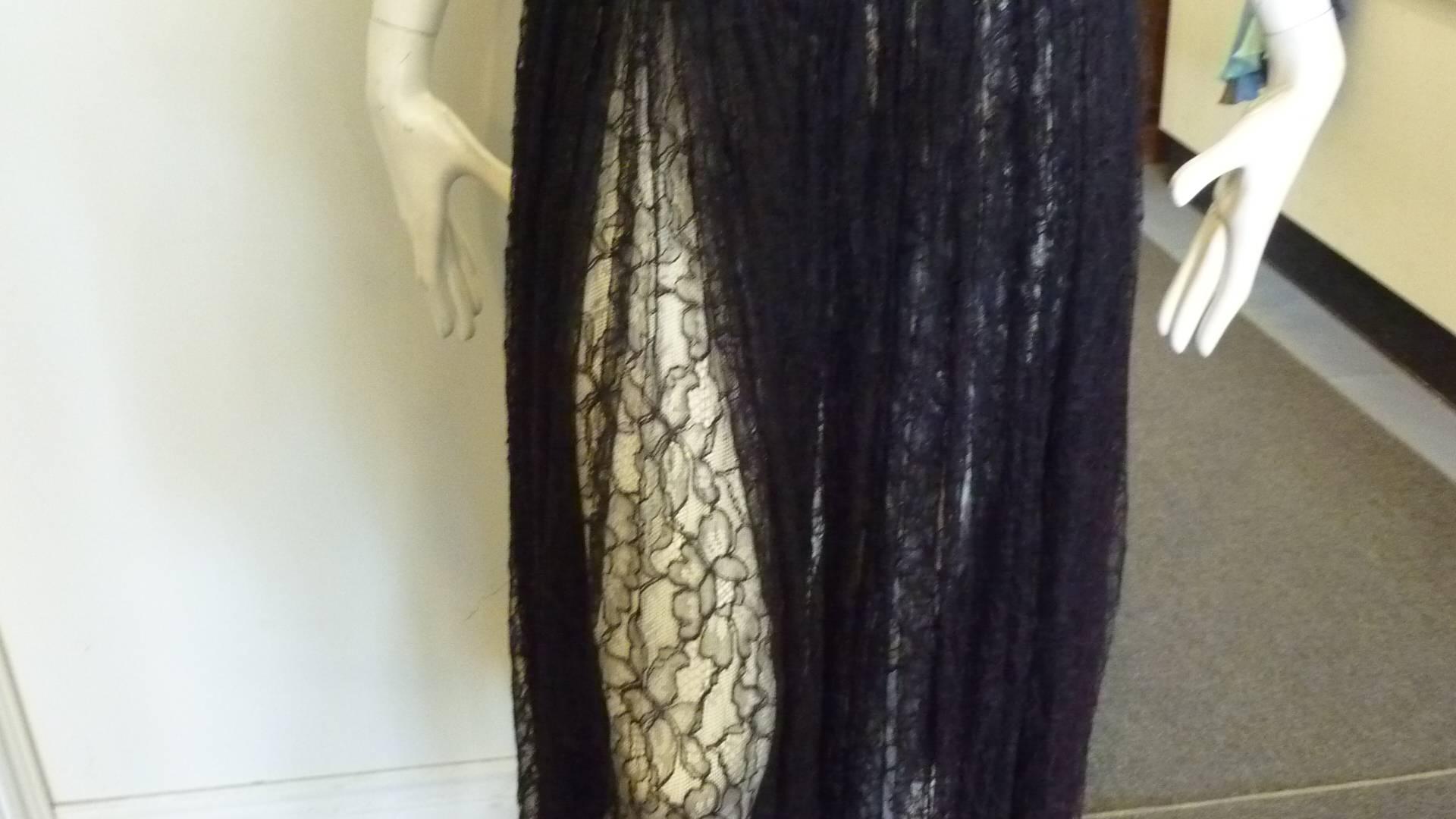 Wonderful mix of a black satin (rayon/cotton) top and lace (acetate/nylon) skirt with a red tinge. 

With the spagetti straps; slight v, and peek-a-boo lace skirt, this dress is an ideal party dress.

Closure is by a back zipper.
