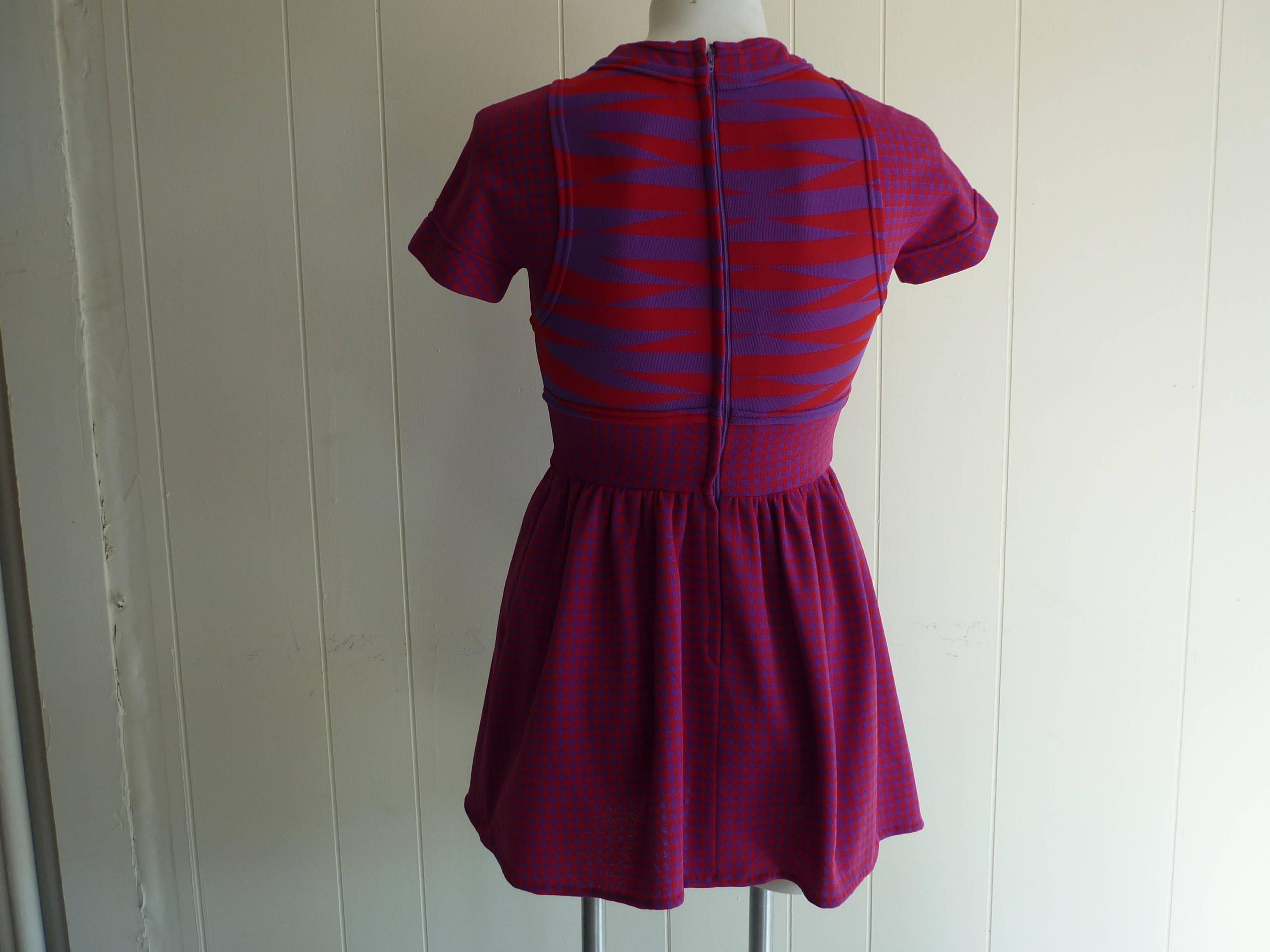 This is a lovely example of Rudi Gernreich's work! The dress mixes colors (red and purple) as well as patterns, especially on the bodice. In fact this dress looks like a two-piece.

The fabric is polyester and was sold at Lord & Taylor Fifth