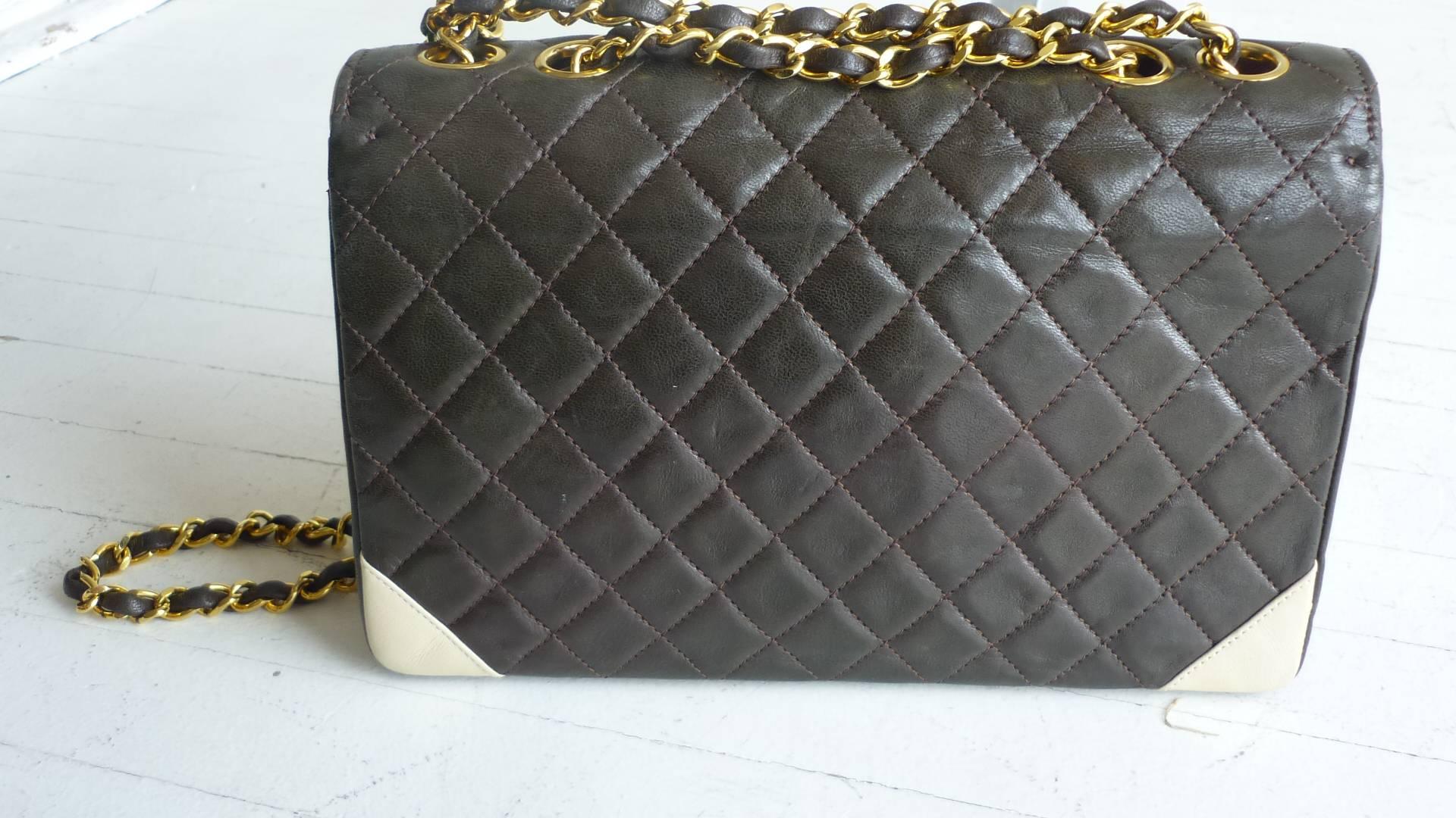 The handbag is made with signature quilted pattern lambskin, with the four corners and flap edge in beige leather. The lining is of burgundy leather with the big CC, made in France and Chanel Paris (see pictures).

There are two inside patch