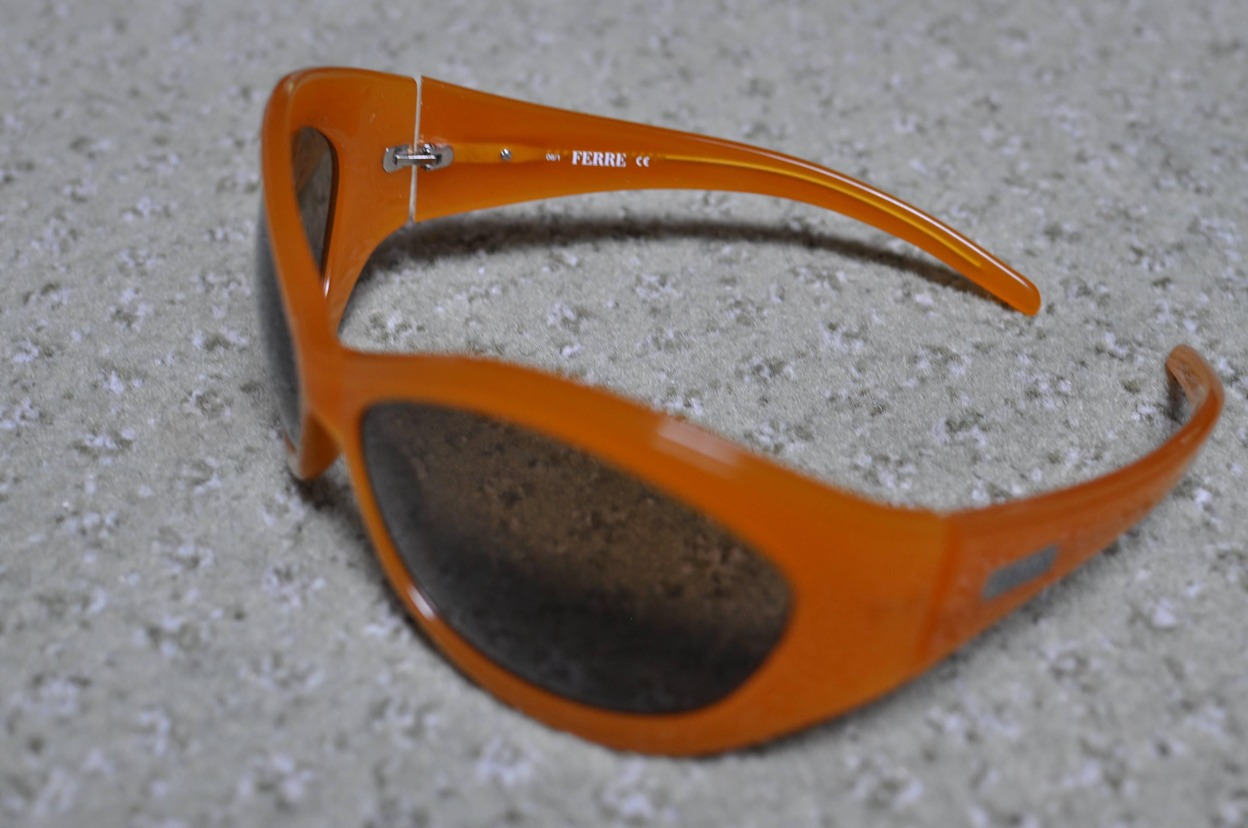 In as new condition, these caramel colored sunglasses are made of plastic with metal 