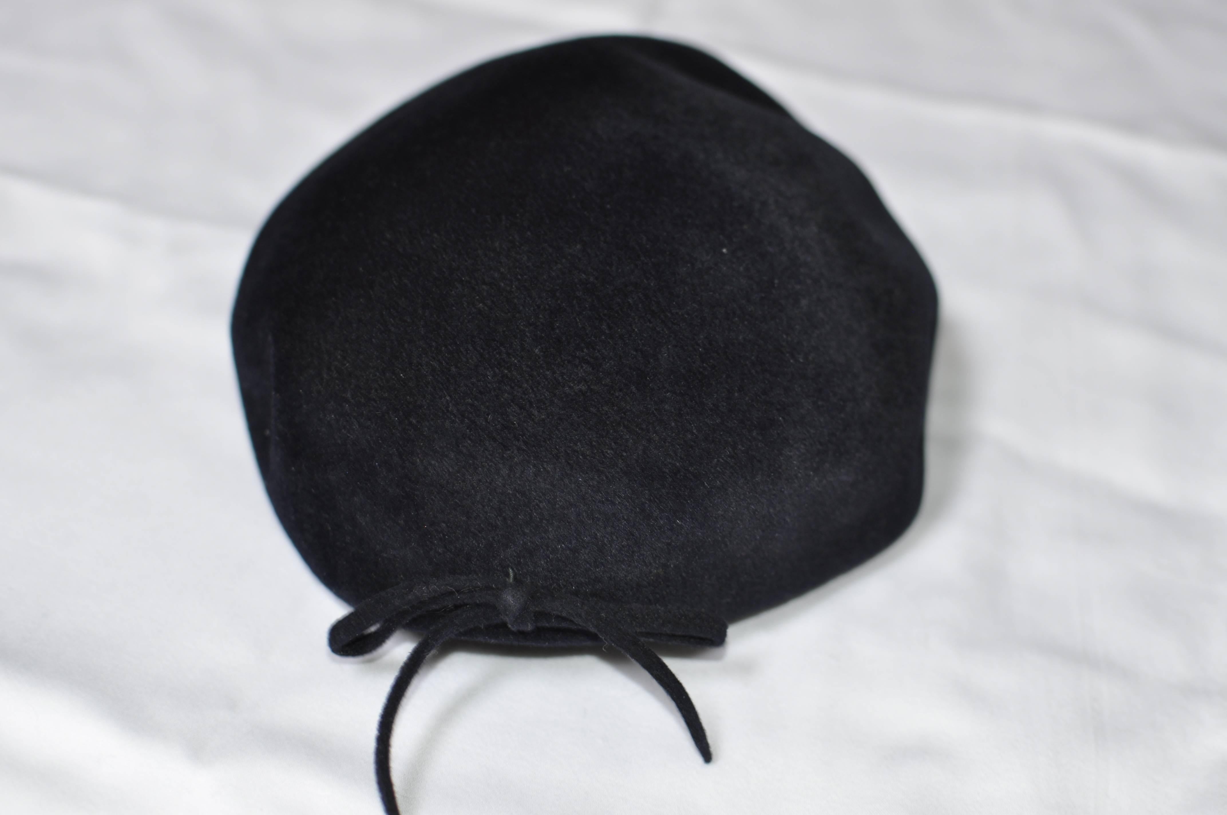 Great little hat with wire insert to keep its shape and discreet bow to the back. The material is velour and it still has its inside cord intact.