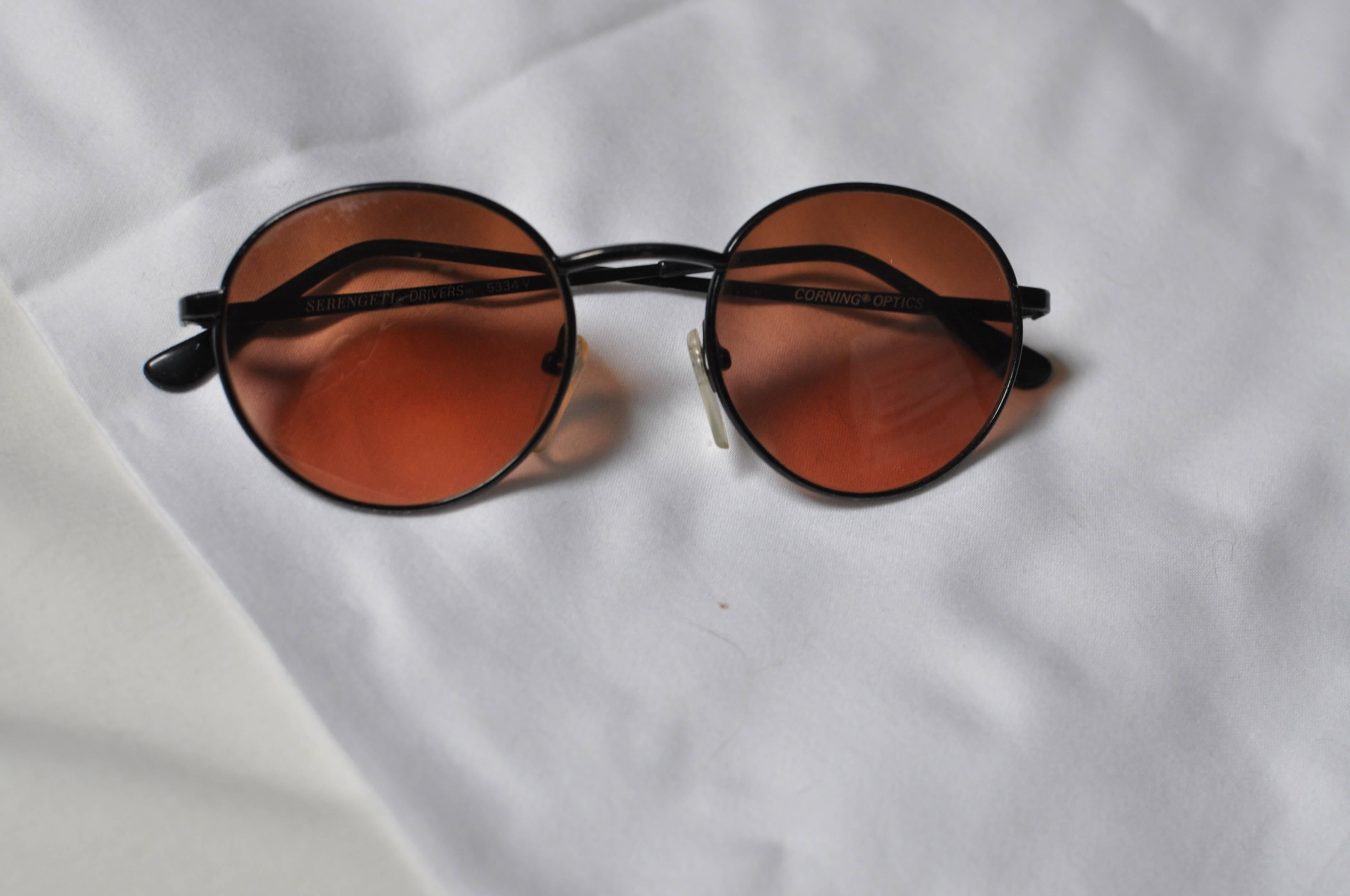Black metal frames with Corning Optics rose colored lenses, and non-slip nose pads. In very good condition and in original case.
