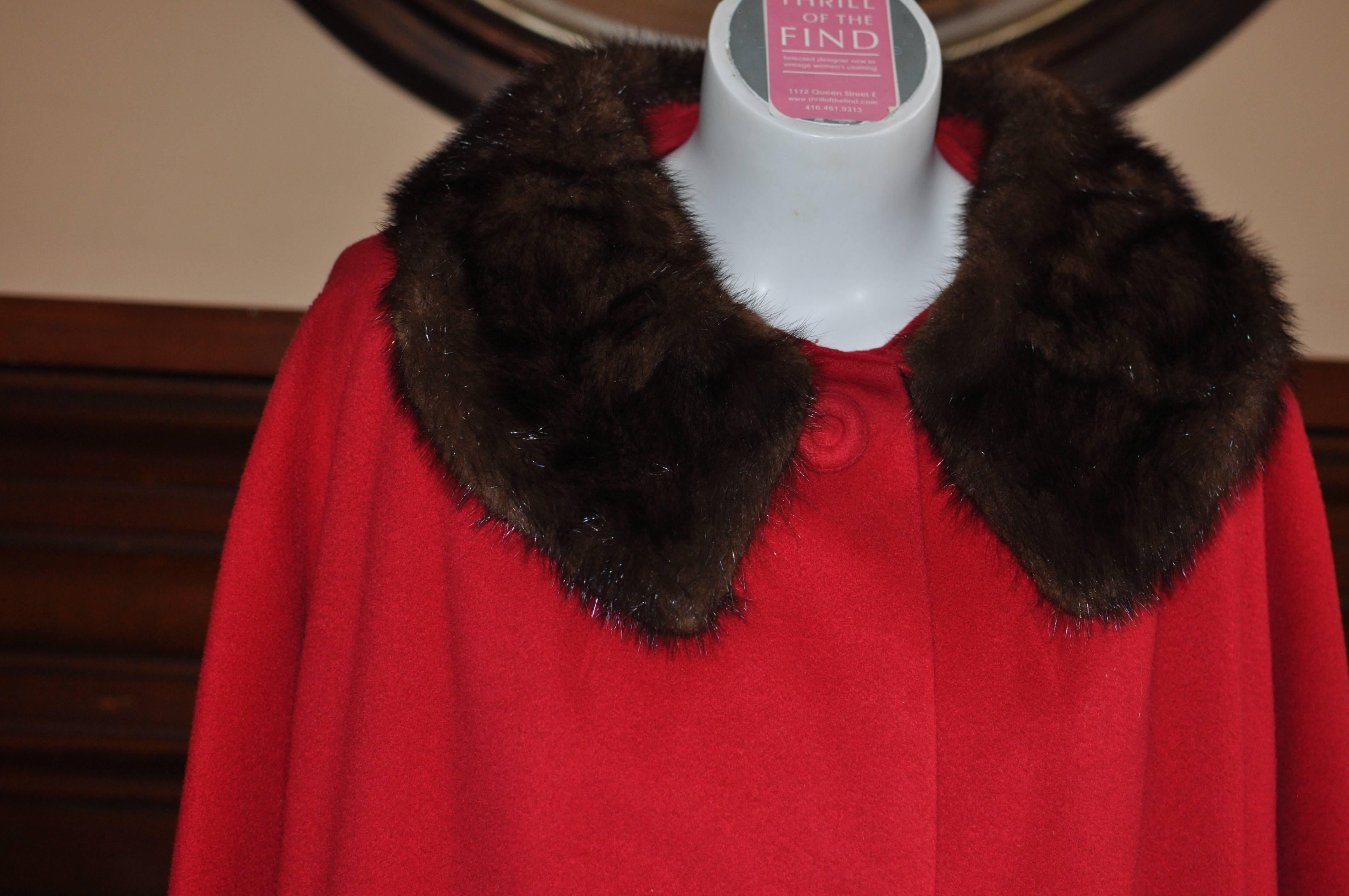 This a 100% cashmere coat in a lovely blue red which has been stored and is in pristine condition. It is hand tailored and has a three covered button front closure, and slit pockets. The collar and cuffs are mink. 