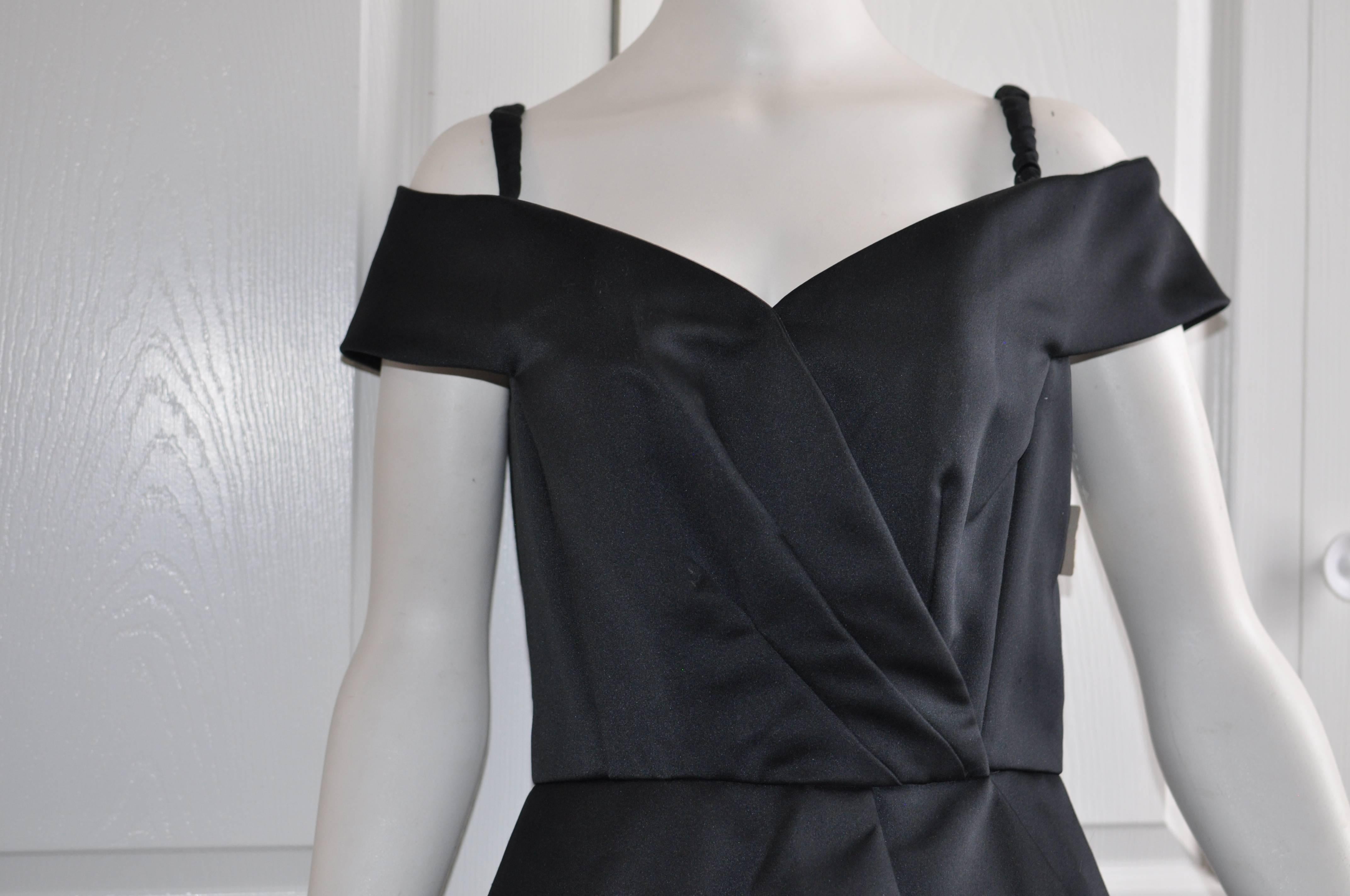 Wonderful cocktail dress with a sweetheart neckline; boning; snap fastening at bottom of V and waist; gathered pleats, and skirt which presents in three layers. Made in the USA of polyester.