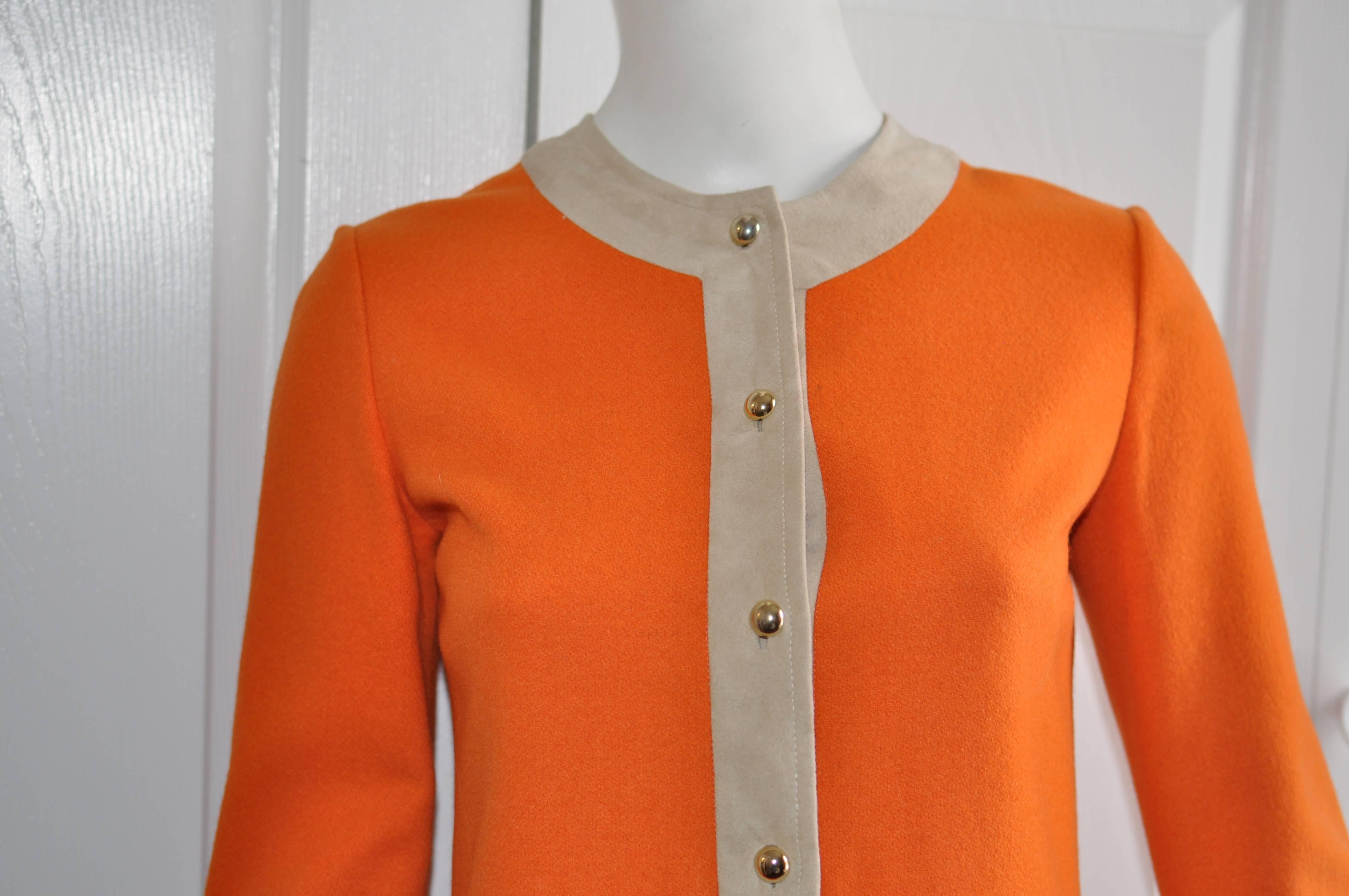 This wool shift dress was carried by Eaton's Chelsea Place Room and was designed and manufactured in France, Although there is no designer label, it is reminiscent of Cardin and Courreges.

The  burnt orange dress is trimmed with beige suede; has an