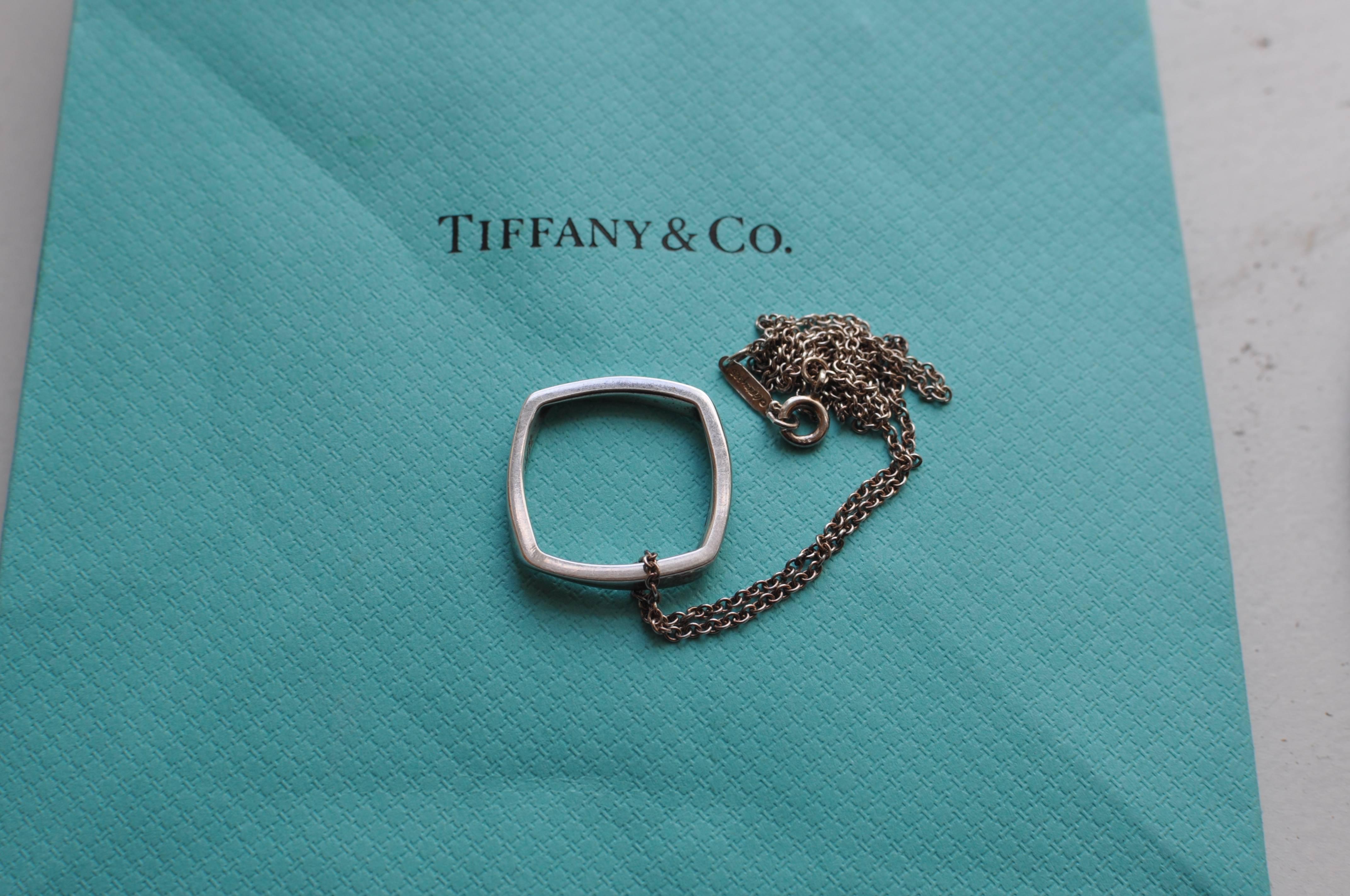 This is the Frank Gehry Torque pendant made for Tiffany & Co. The pendant has an inscription but also carries the Tiffany & Co. (c) Gehry 925. The chain is silver and the clasp marked with Tiffany & Co.