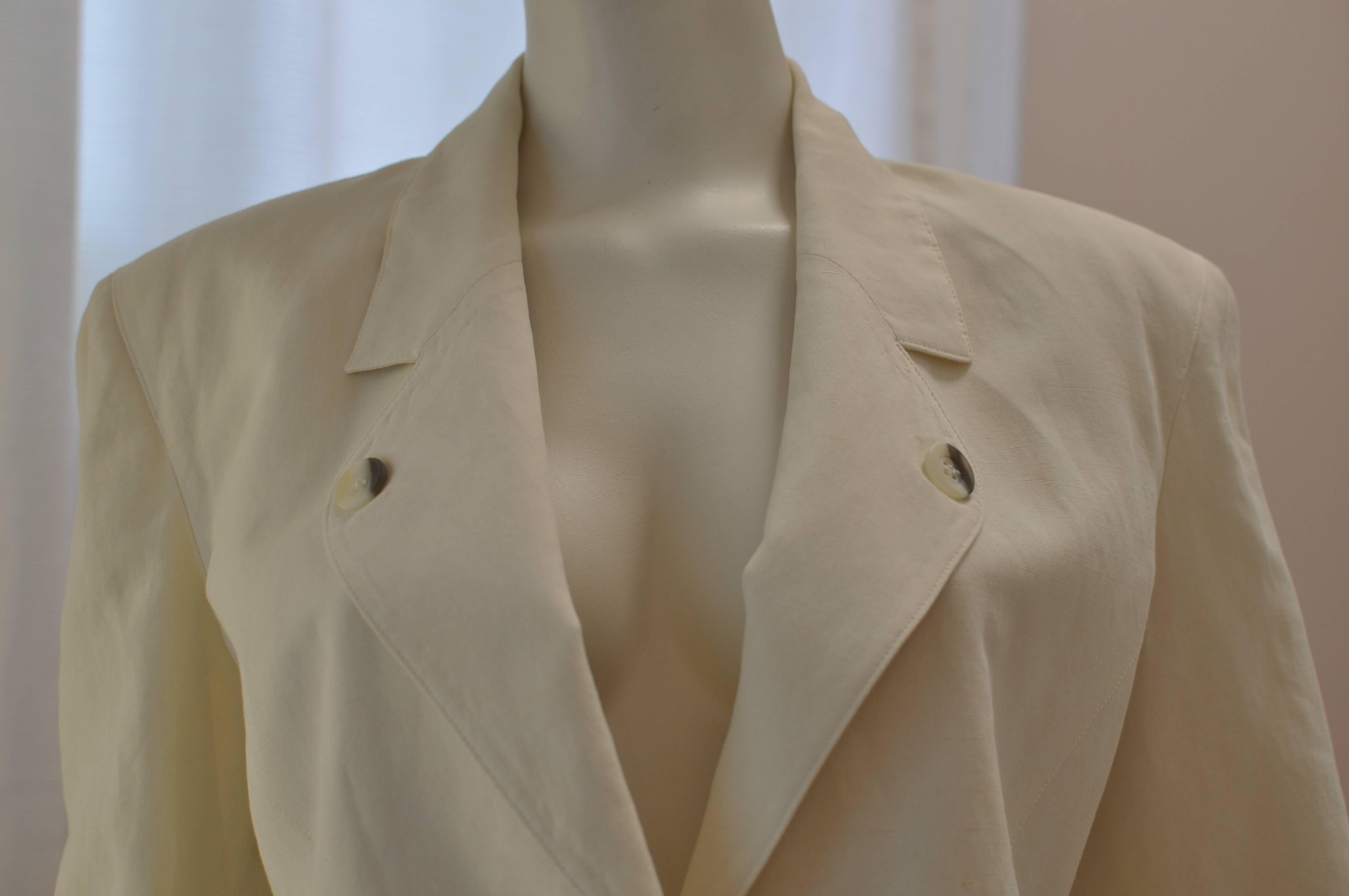 This tuxedo style jacket is made of a linen blend and has a notched lapel with a button each side; a one button closure; two slit pockets which have not yet been used, and 3 buttons on each cuff.