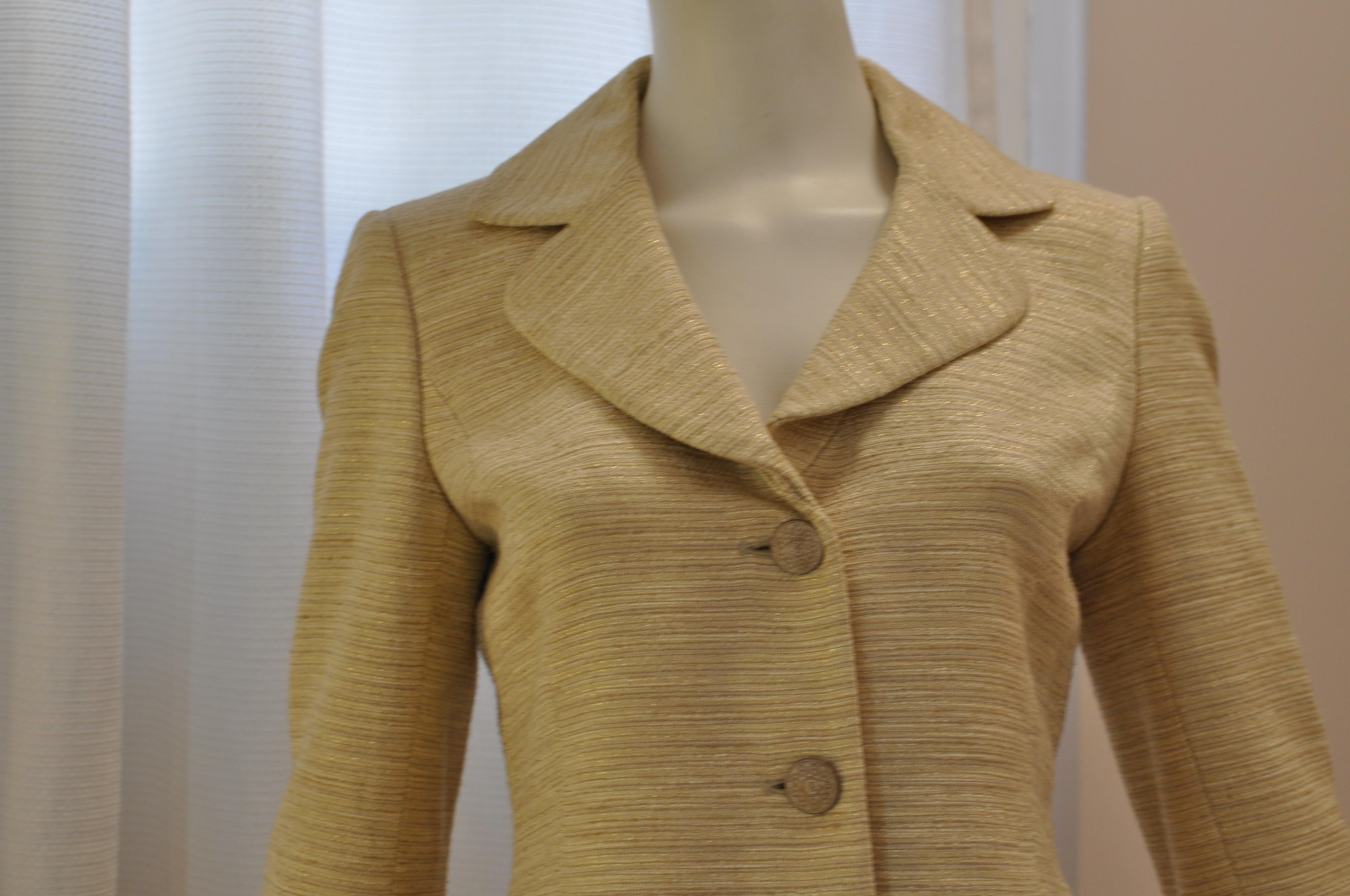 This jacket glimmers with a combination of cotton and acetate with gold fibers running through it.  The jacket has a very nice notched collar; contrasting grosgrain cuffs (replicated with button band); an extra button still attached to the care