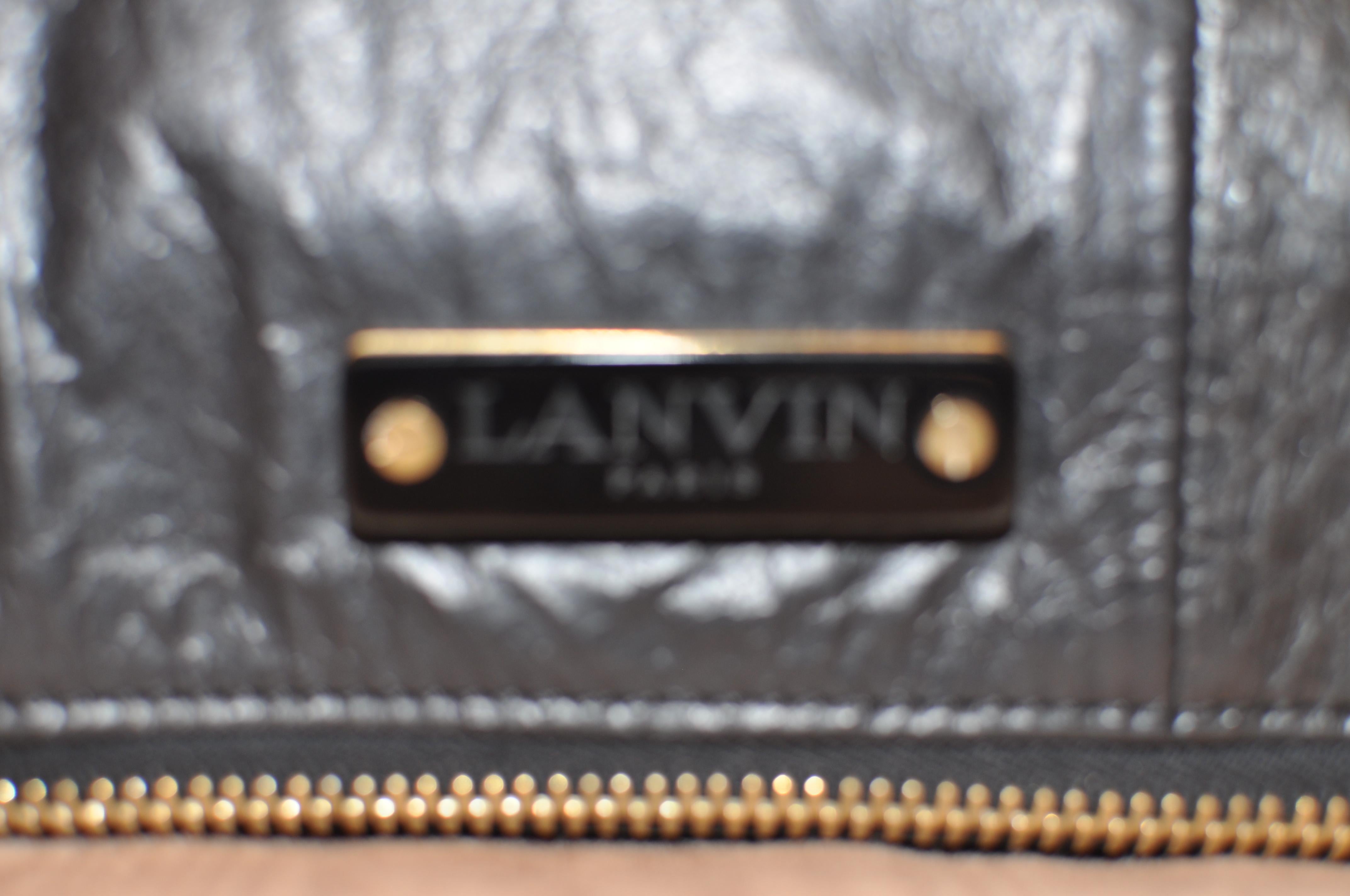 This is a foldover flap clutch/handbag, which we believe is from the 2015 collection. Materials are patent leather and reptile. The bag has a wide wraparound zipper, fold over and closure is by a magnetic strip. The inside lining is gold with a