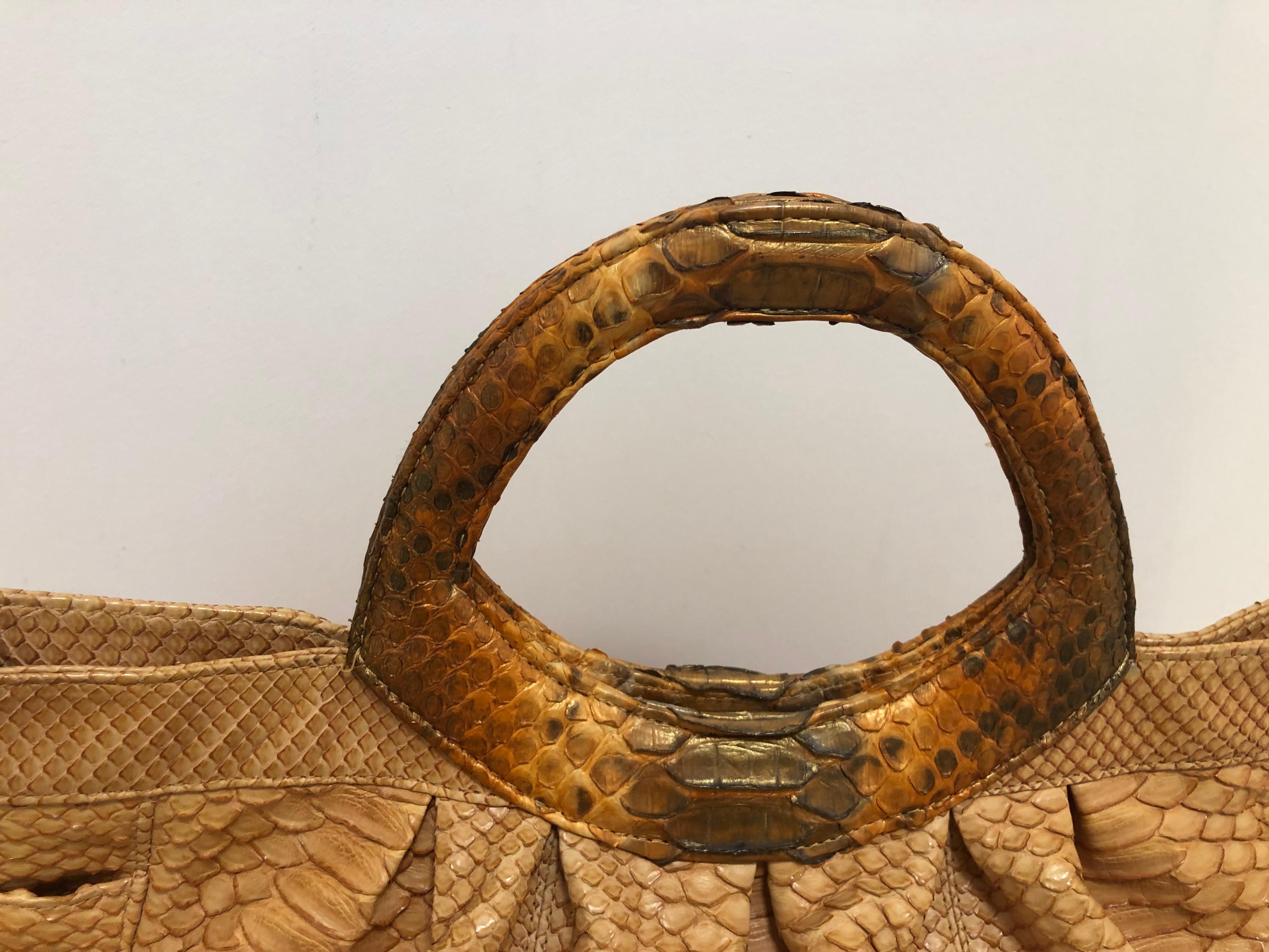 In fantastic condition, this very elegant pumpkin colored python handbag is manufactured in the USA to the highest standards. The exterior has two small but fairly deep side pockets, and the interior is in very good condition with lined with woven