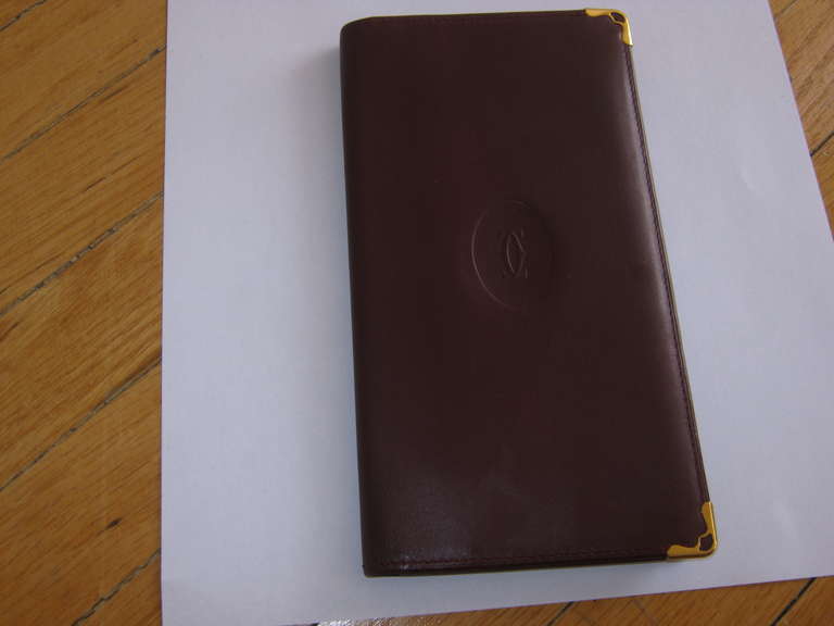 Although not new, this Cartier wallet/card holder in the traditional burgundy is in lovely condition, with stitching and metal corners intact.

There are four slit open pockets as well as seven credit card slots, which make it very practical.