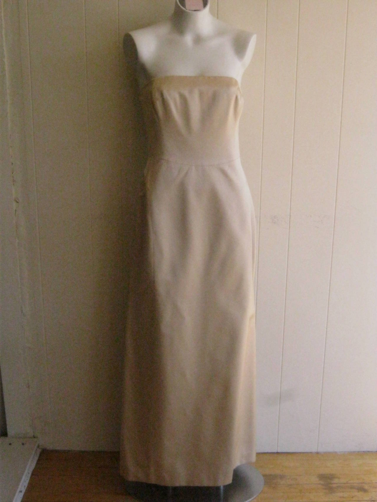 Beautifully cut and tailored strapless champagne colored rayon and silk gown with fishtail train and reversible stole.The bodice is boned and closure is by invisible zipper in the back and an inside ribbon belt. The skirt flares out in a ball gown