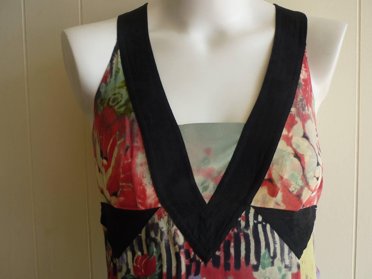 Beautiful silk abstract floral dress with black trim details on neckline and below the bust line. V-neck with a bib middle and slight a-line.