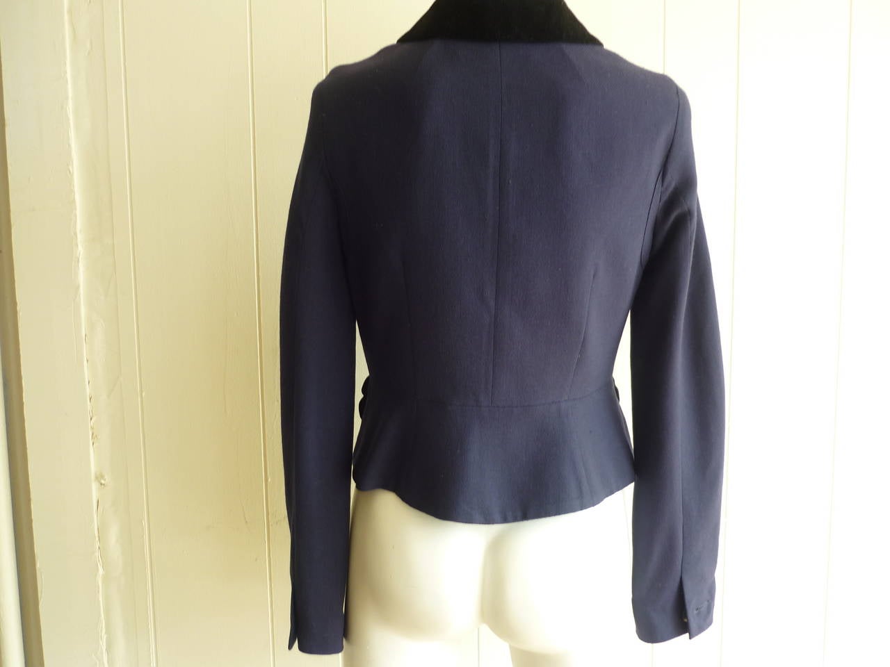Navy blue wool jacket with black velvet pocket bow and collar detail. This is a very 1940s look with down to the tailoring which includes a weave effect wool, seamed arm pits and several darts. The waist has a slight cintre effect, and there 5