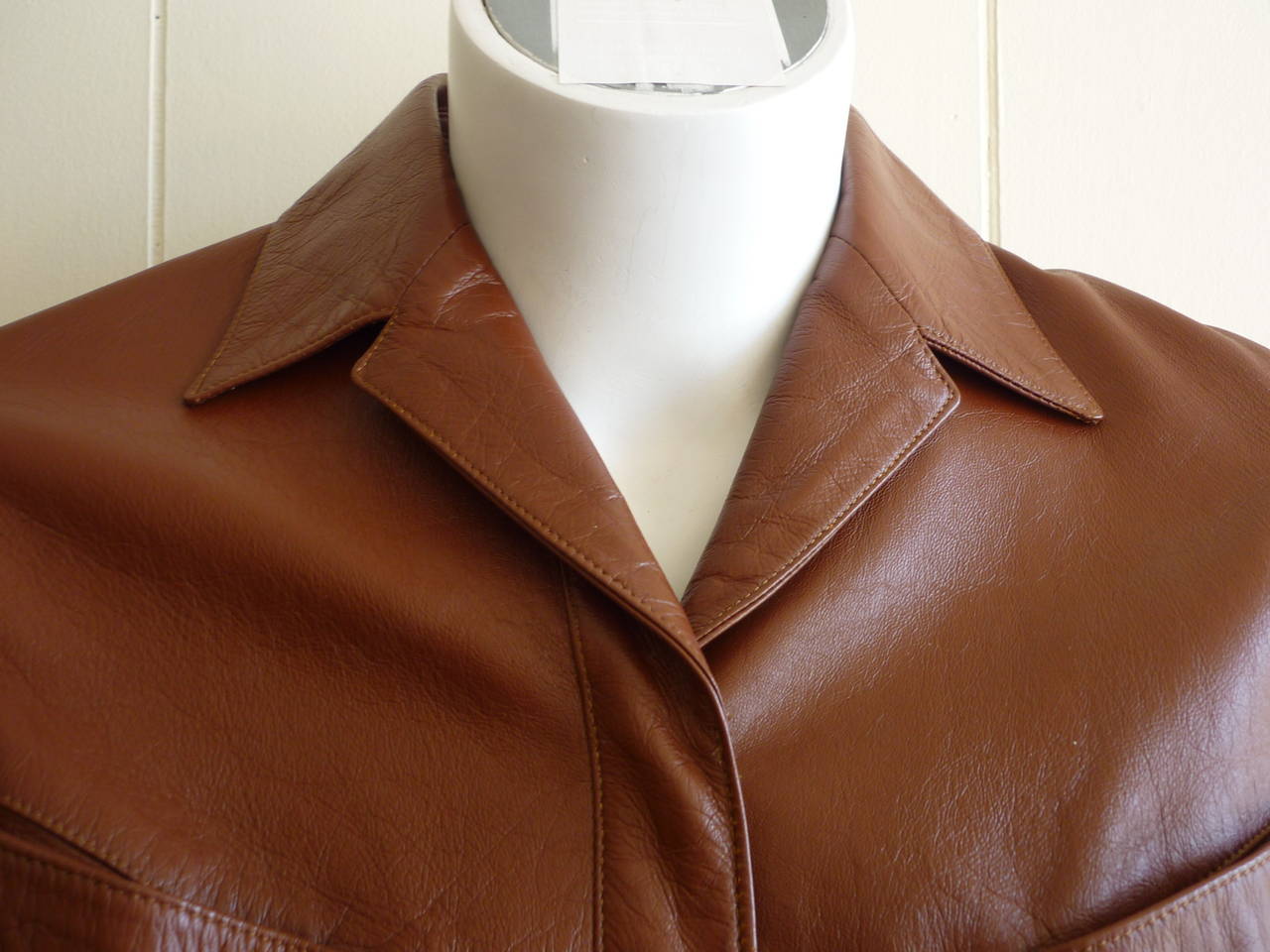 Perfect leather jacket with the iconic snap buttons and slant pockets. The jacket is a warm brown leaning towards orange tones and is embellished by two side buckles.