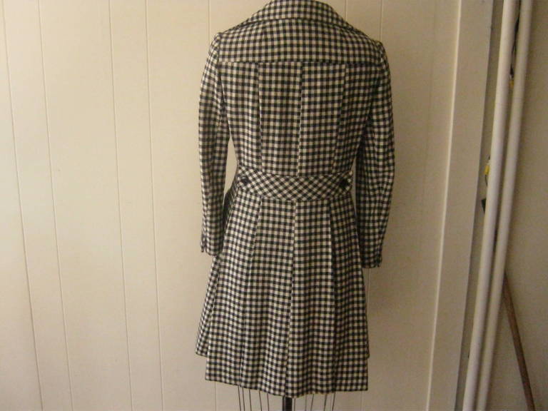 This black and white check pattern wool coat will always be in style! It has a slight A-Line two deep pockets in front, and the back sports a half belt and discreet wide pleats from the bottom of the shoulders to the hem.

There is also a double