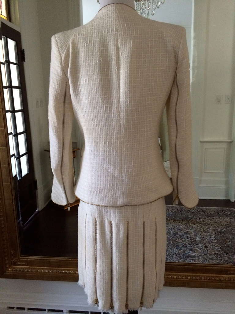 No one does construction of a fitted suit like the late, great Alexander McQueen. This light boucle wool in off-white is detailed in with sharp gold zippers. The skirt is literally shaped ingeniously and simply with zippers from on all sides. The