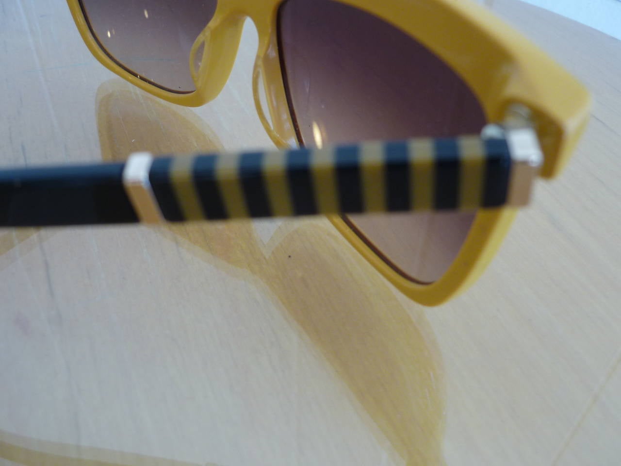 Unusual combination of treatments: The color is a vibrant mustardy yellow and the contrasting stripped design is used to enrich and enhance frame features.

The frame is acetate and the lens poly carbonate. There is a saddle bridge and the Fendi