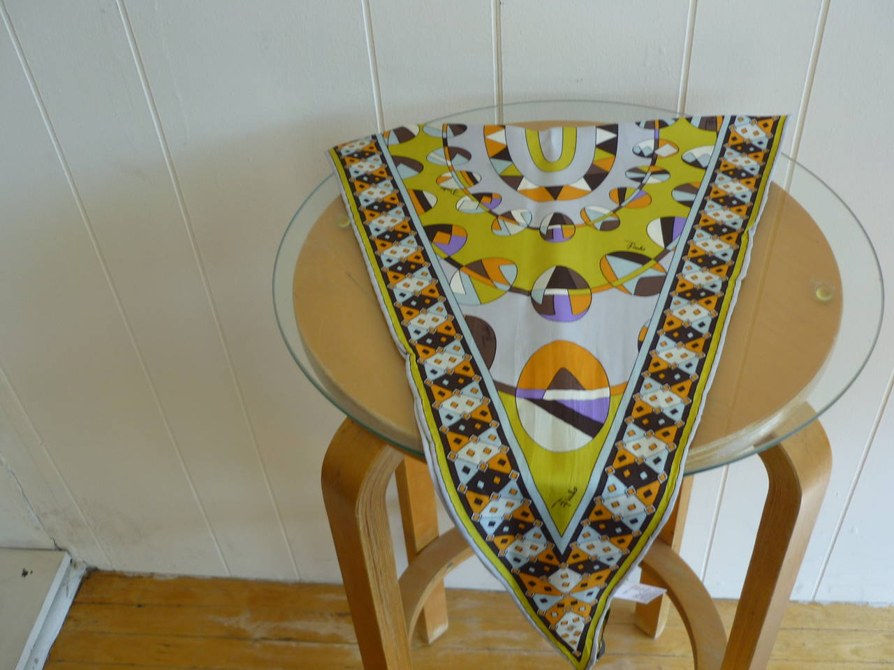 Unusual shape with an Easter-like geometric pattern. Apart from the yellow other colors are orange, pale aqua, purple, grey, brown, chocolate and white.

The Emilio signature is scattered throughout the scarf.  Wear it around the neck or as a