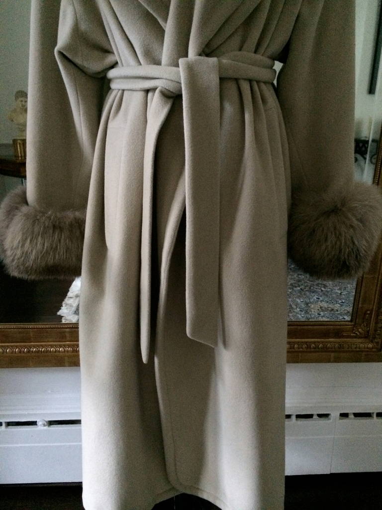 Fabulous wrap coat with fur trimmed sleeves. Designed in a beautiful and luxurious ecru cashmere with belt. Lightweight and truly elegant. Perfect piece to wear all winter with darker tones. 

Size 4 US