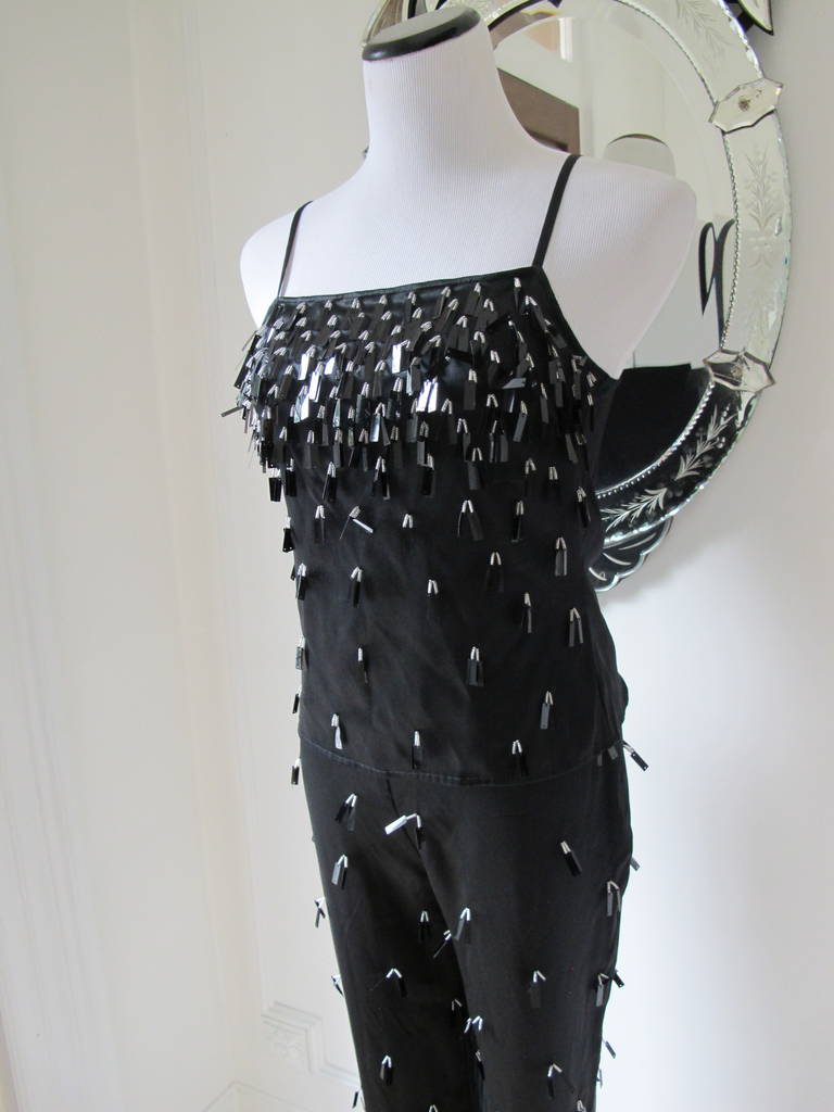 Every eye on you in this Gianfranco Ferre three-piece beaded cocktail pantsuit.
Silk fabric intricately beaded in black, white and silver. Feminine spaghetti straps on the camisole top. Truly glamour for an unbelievable event or night on the town.