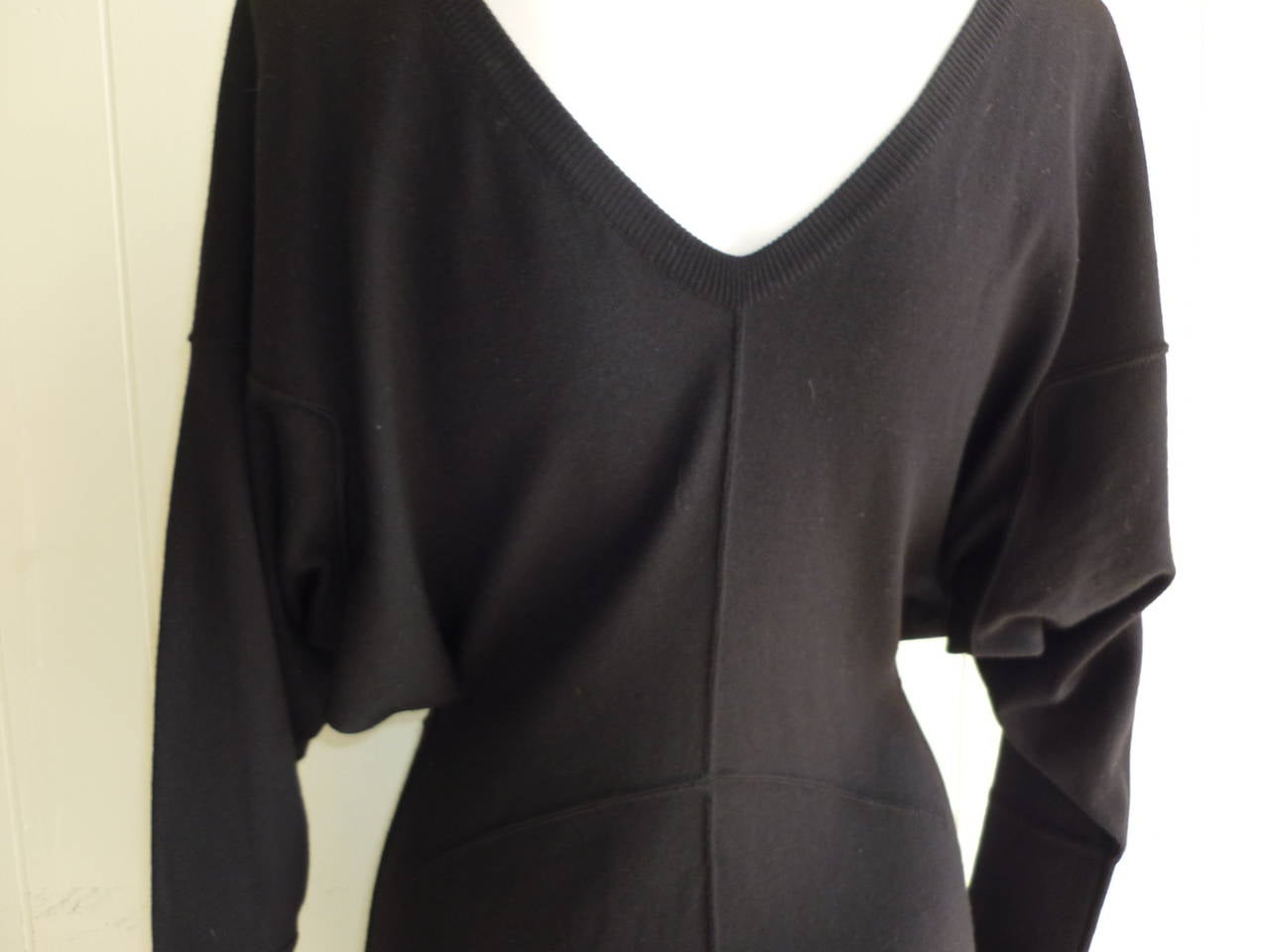 Lovely soft wool dress with a ribbed crew neckline and V-shaped lowish back. The butterfly sleeves narrow at the cuff and of a thicker wool for accentuation, as is the bottom of the dress.

Other suttle details include well placed wool seams.