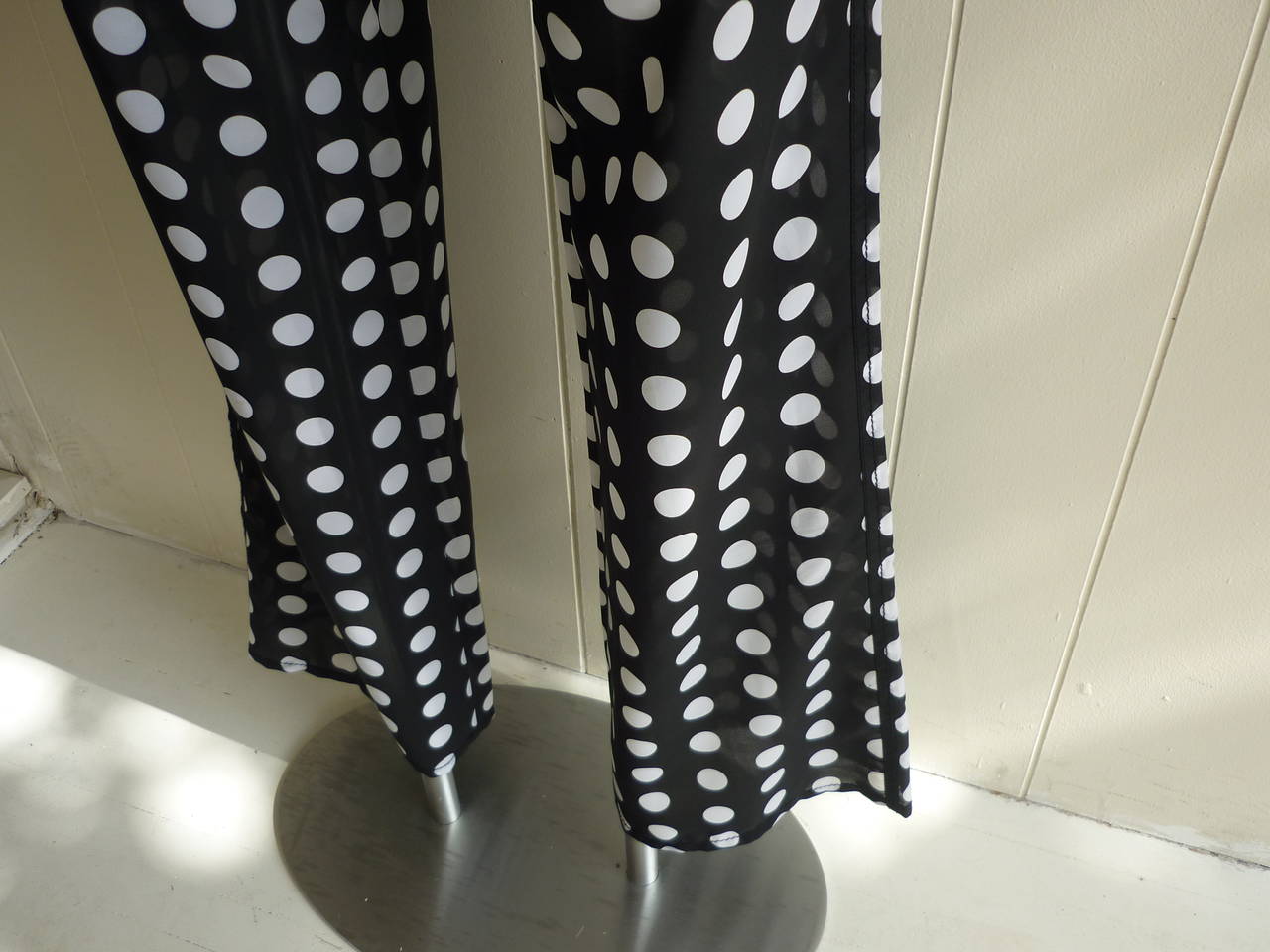 Lovely piece! Sheer and lightweight, these black and white polkadot low rise and flared pants have two pockets in front as well as the back. Closure is my way of a zipper on the front and there are belt loops if you wish to add a belt. There is