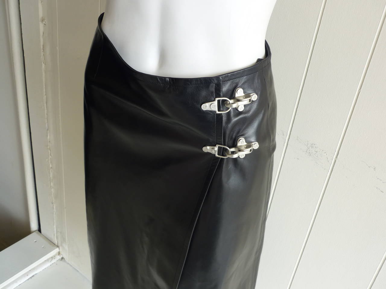 Beautiful lined lambskin wrap skirt with silver hardware fastening incised with the Celine logo.

The fit is slightly assymetrical allowing the leg to peep out at the bottom.
