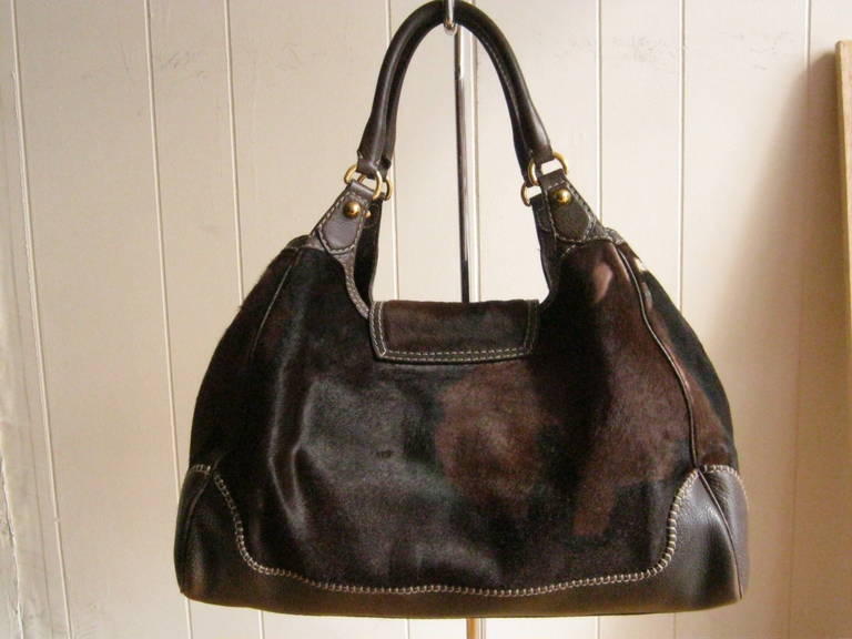 The combination of pony hair, which reflects the actual fur and its many tones, as well as dark brown pebbled leather trim with beautiful stitching, make this a very desirable bag.  

Add to that a dark brown buttery soft leather lining, horsebit