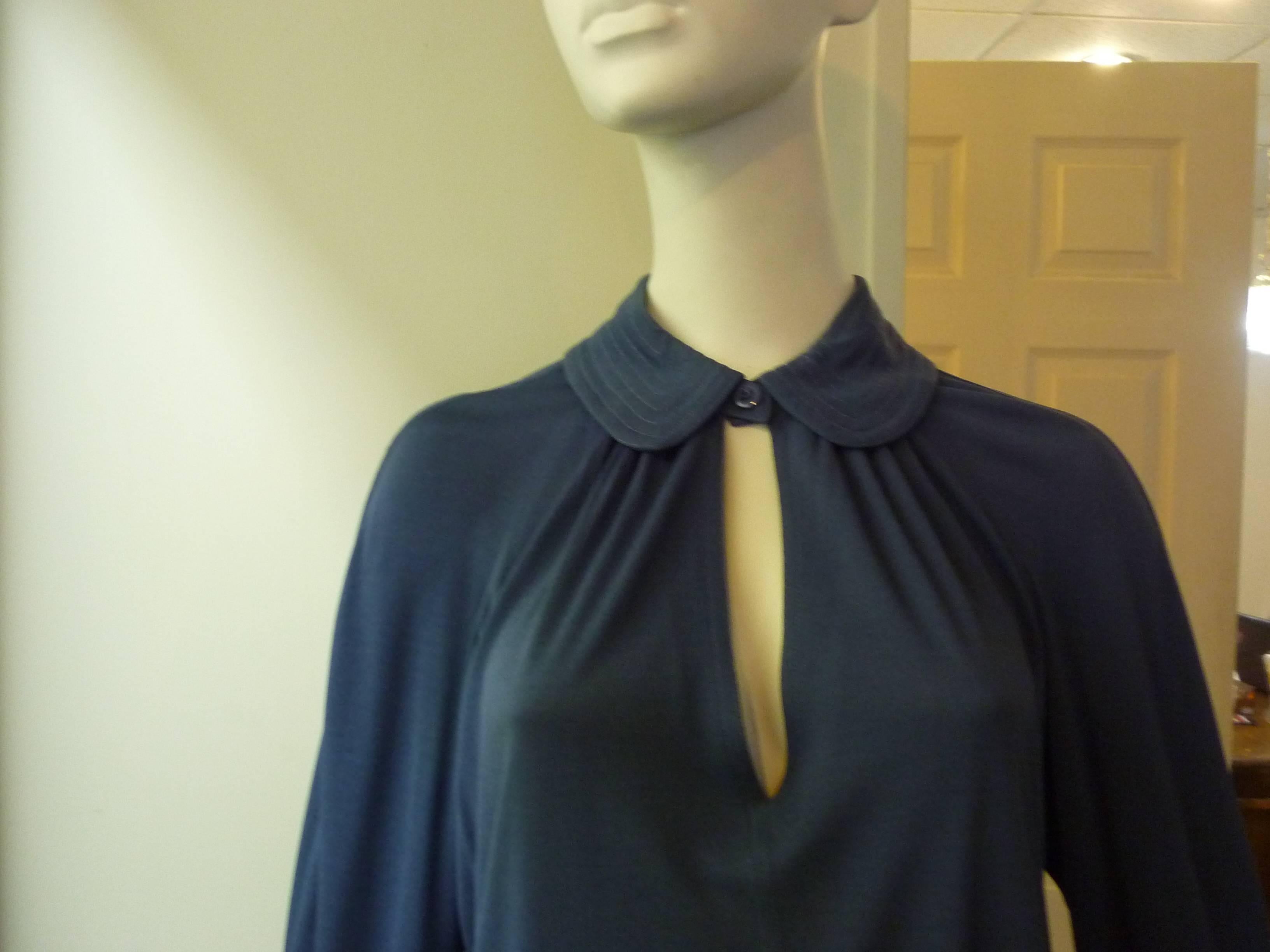 Iconic Jean Muir Style with a lot of stitching detail; one button closure at the neck with peek-a-boo neckline; turned up cuffs with decorative 