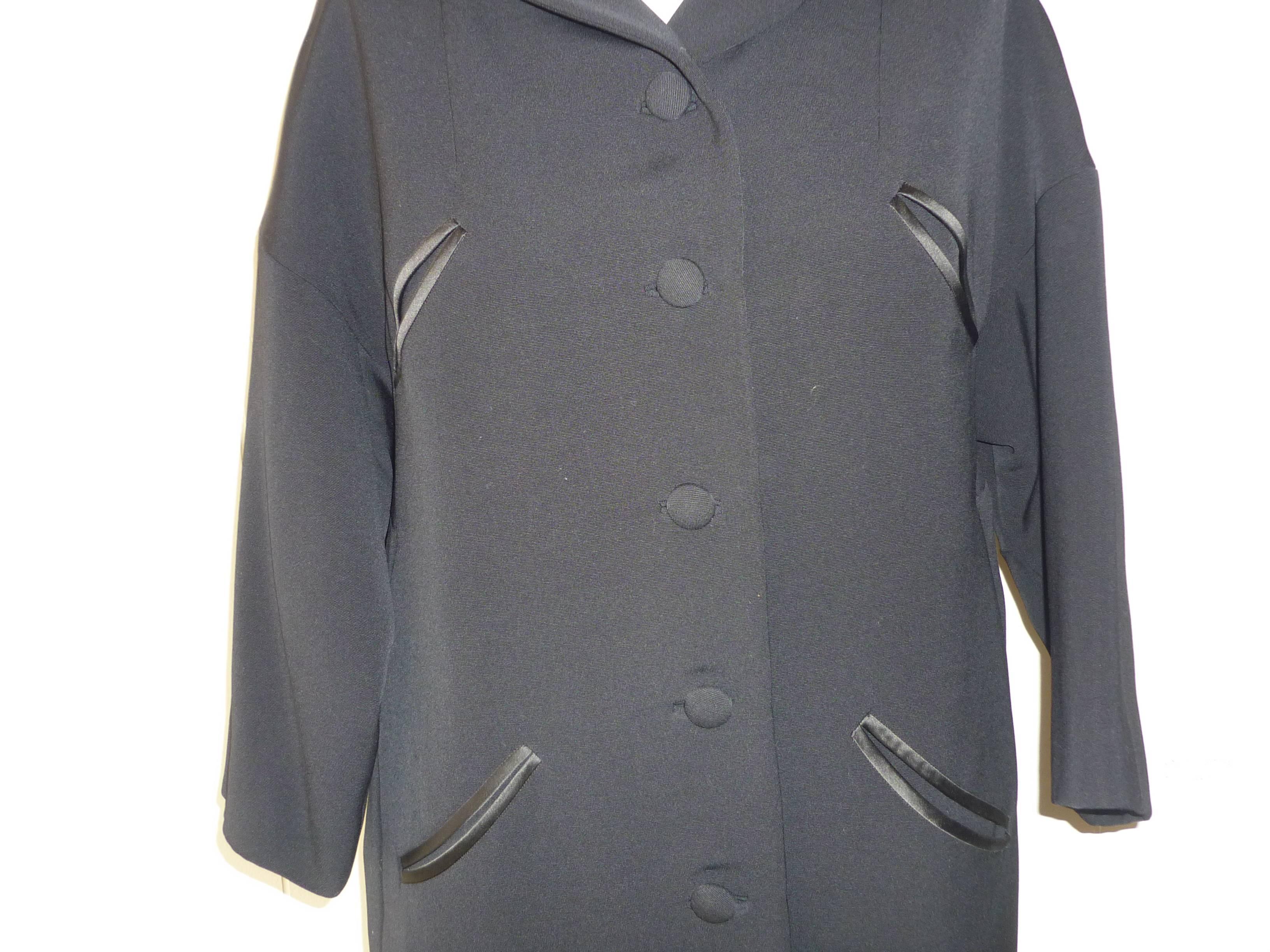 Beautifully tailored heavy novelty wool coat fully lined; with four slit satin bound style pockets; three quarter sleeves and bound button holes.