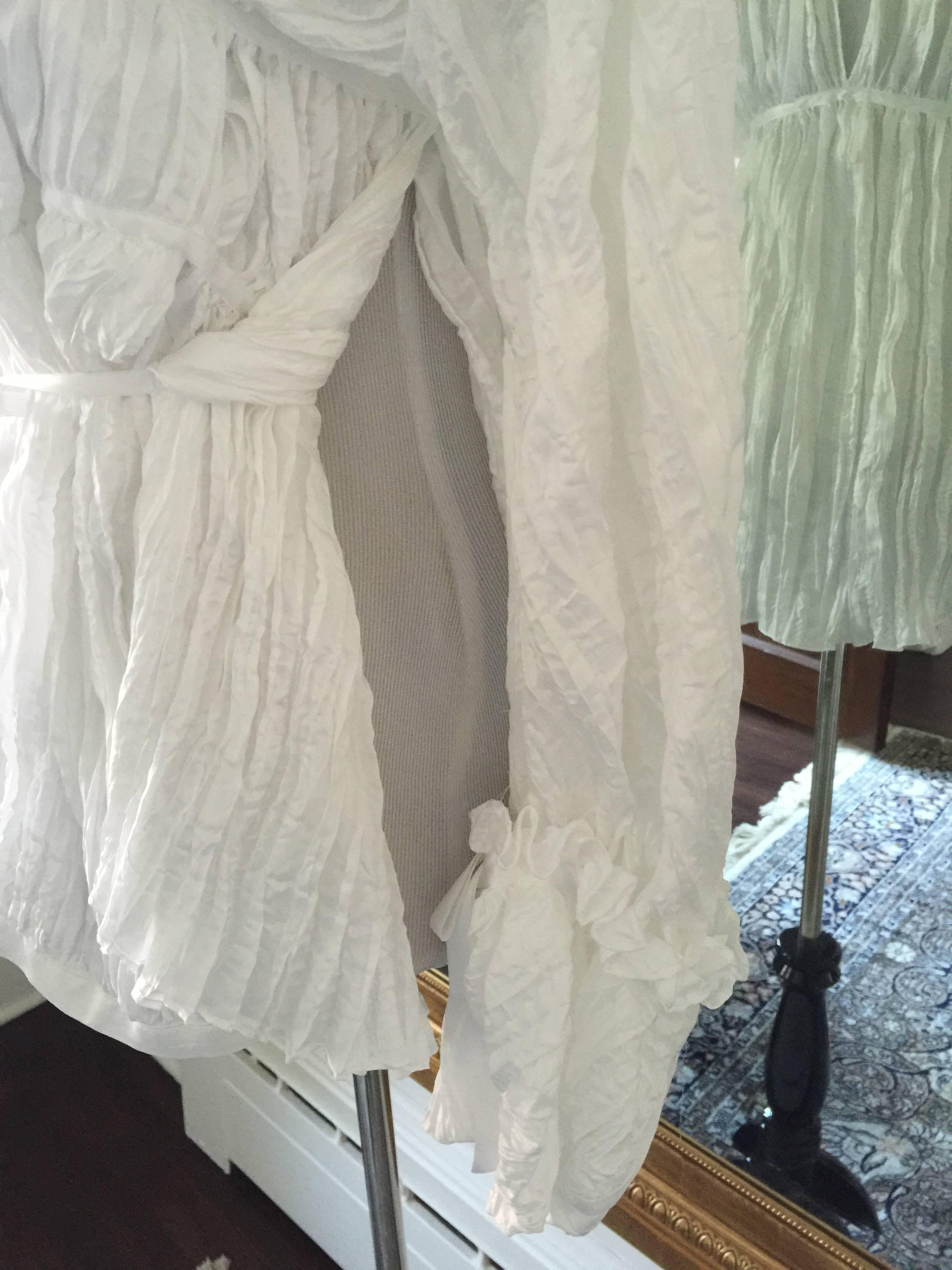 White crinkled ruffled blouse, perfect for this summer to wear with short pants. The blouse has over sized sleeves with a large ruffled collar, and tie front and the back.