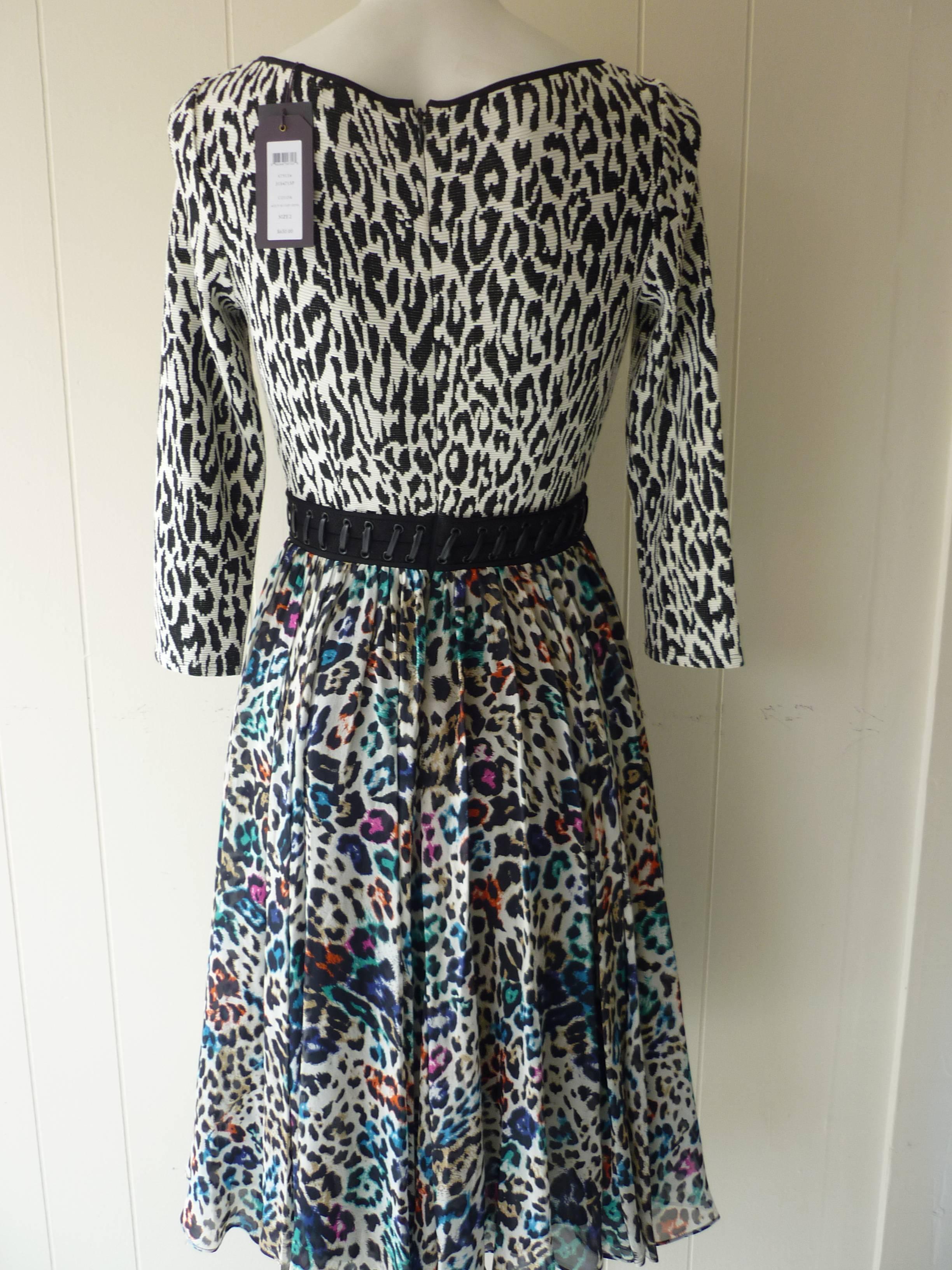 Multi print and different textures, make this silk and cotton dress a real statement piece. There is a full skirt and lace up detail at the waist. Closure is by a hidden back zip.