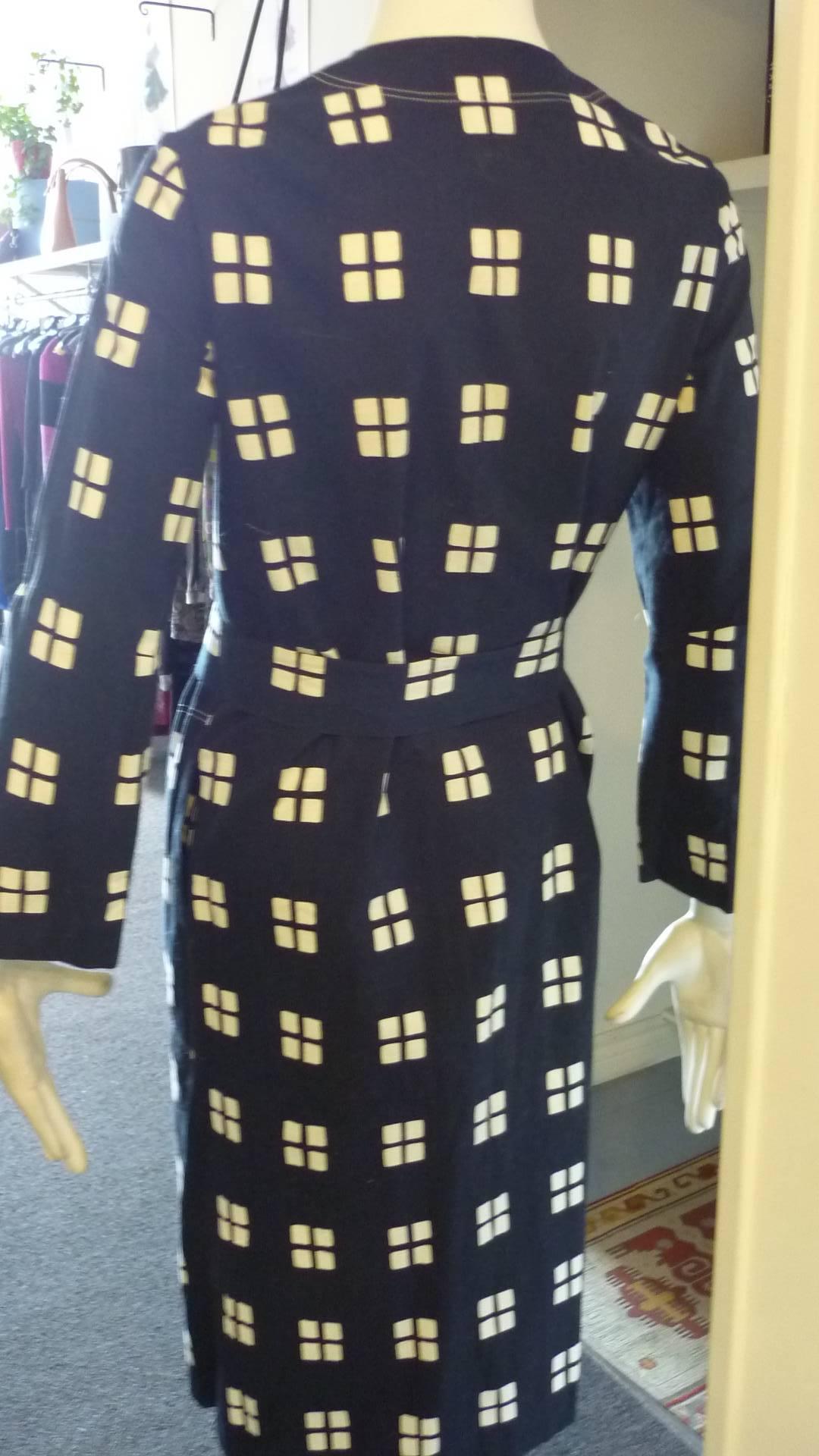 This is a striking print! The dress has a v-neck; assymetric snap front closure; two outlined side pockets, and a belt.