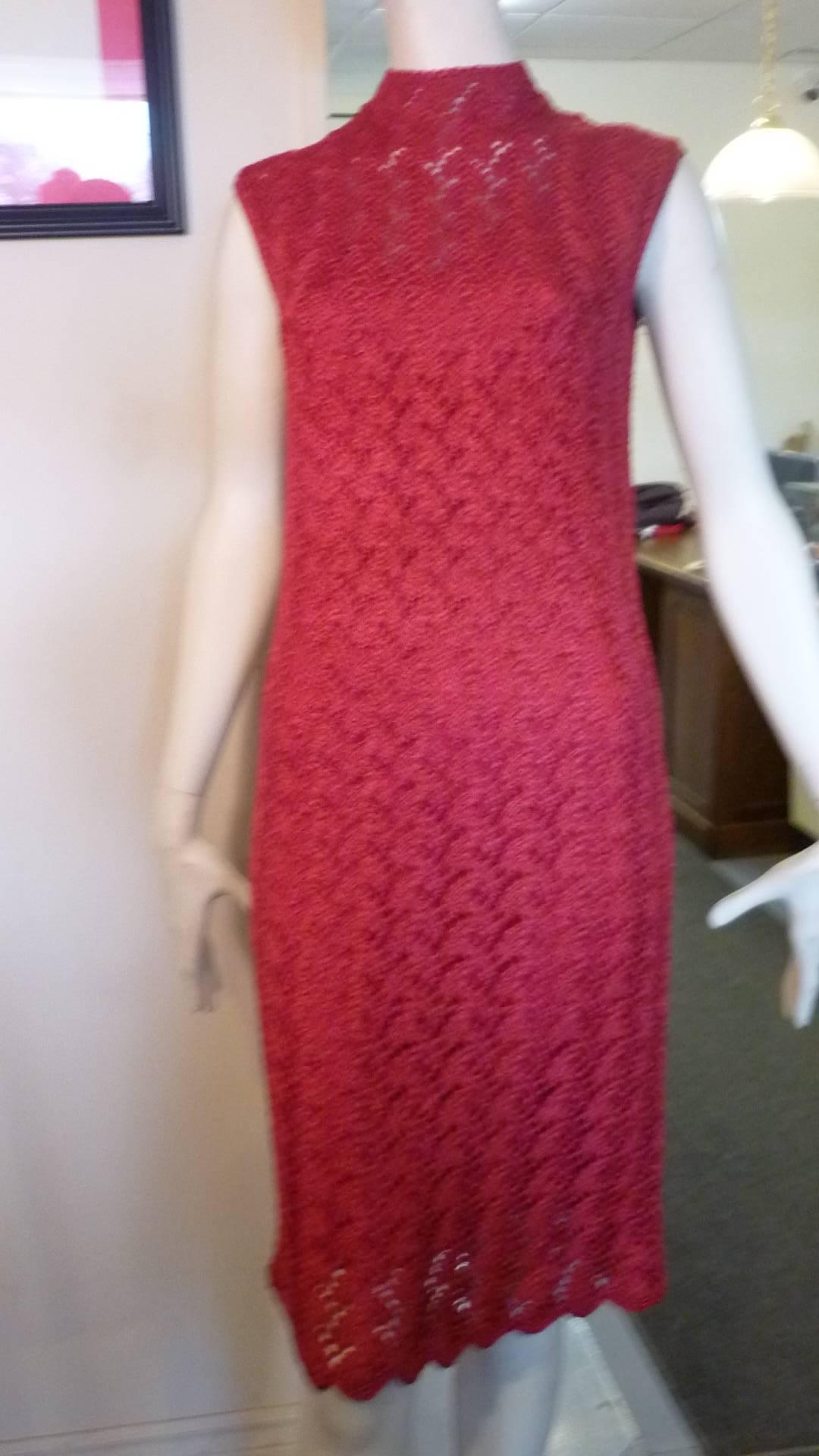 This is a beautifully made rasberry pink dress with a high collar; full lenght shell; scalloped hem, and braided belt.