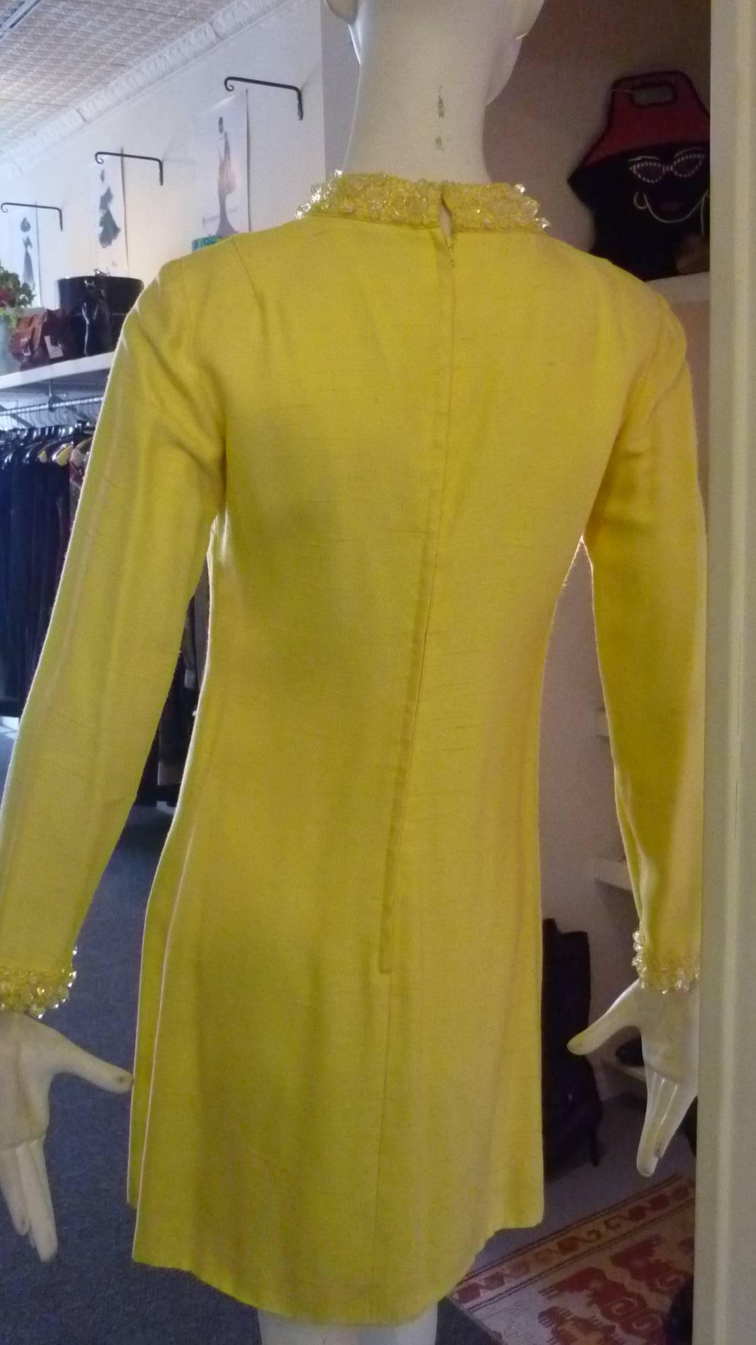 1960s dress in fabulous condition with a high beaded neck; beaded down the front as well as the cuffs.Nice darting as well as a bottom front centre pleat.