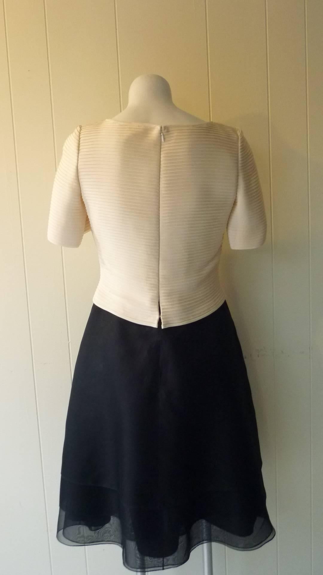 Looks like it could be a two, but it is not! The top has a tiered stitching with short sleeves and a row of covered buttons. The skirt has five panels one on top of another over a slightly aline skirt.