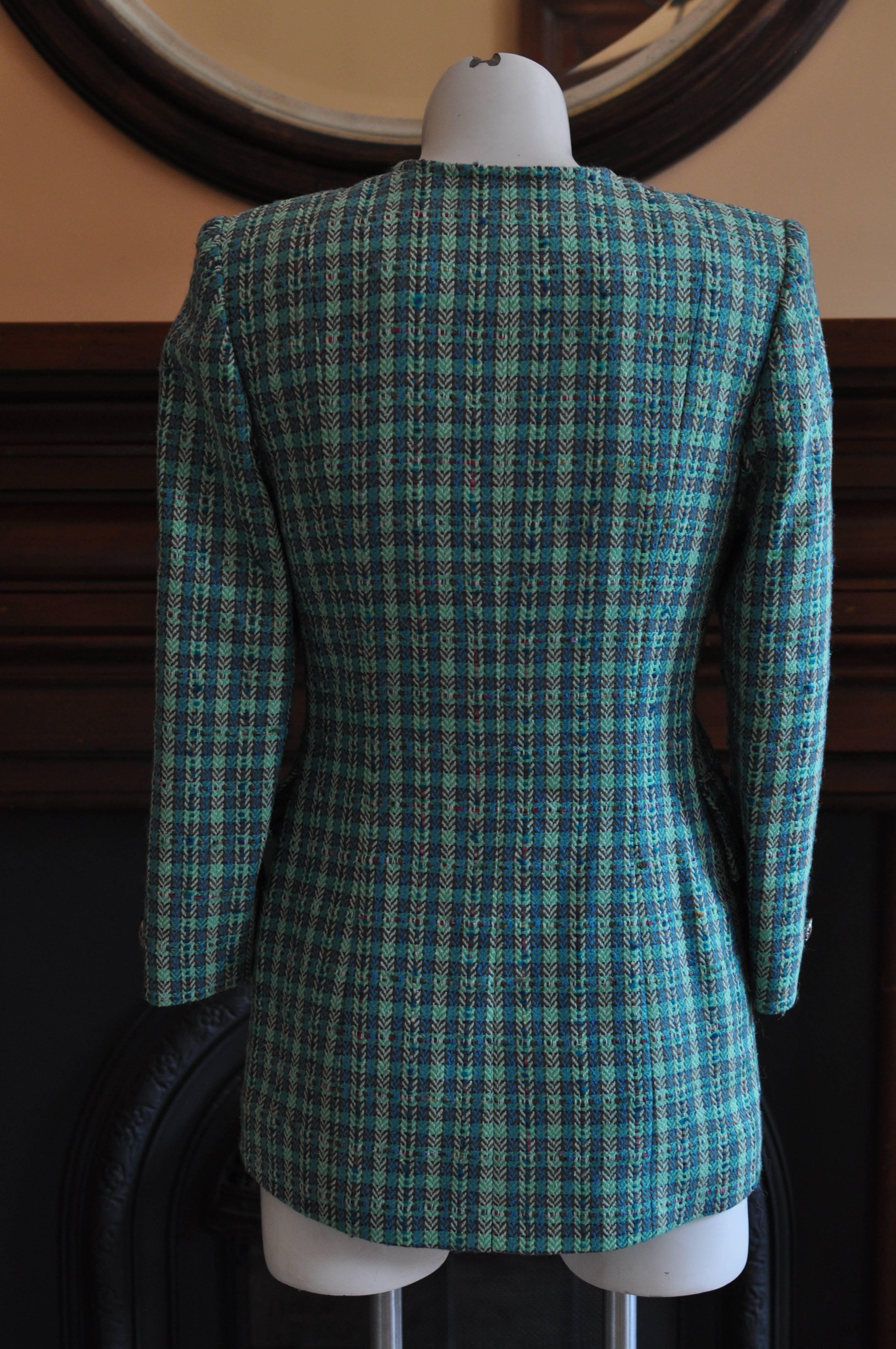 Equestrian jacket look with longer back; v-neckline; two slanted front deep pockets and lovely silver Nina Ricci buttons (6). Multicolored with an emphasis on greens.