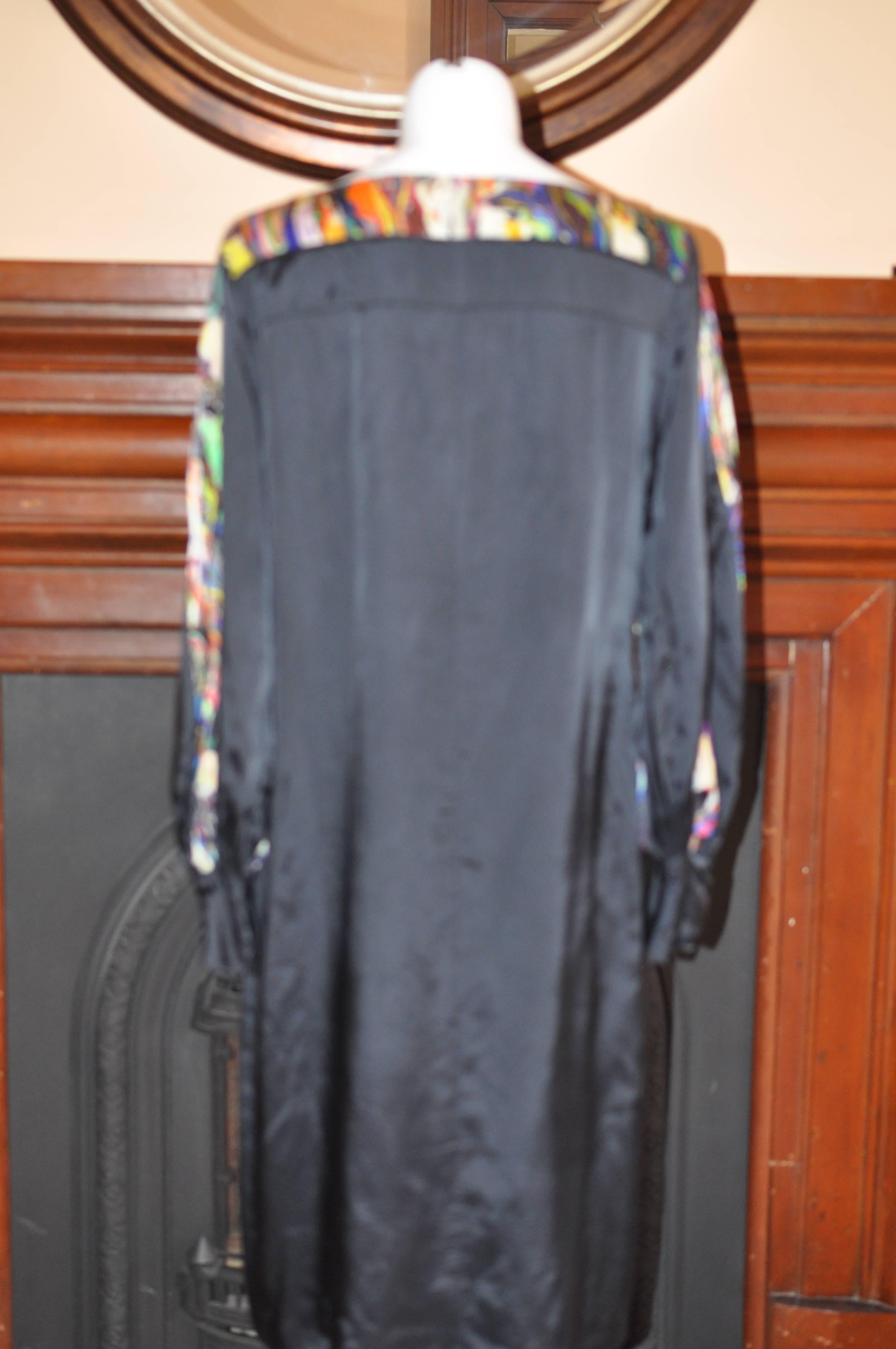 Made of rayon this black dress has a bateau collar; multicolored marble abstract print along the neckline and as inserts on the sleeves; concealed snap button cuffs, and wide balloon sleeves.