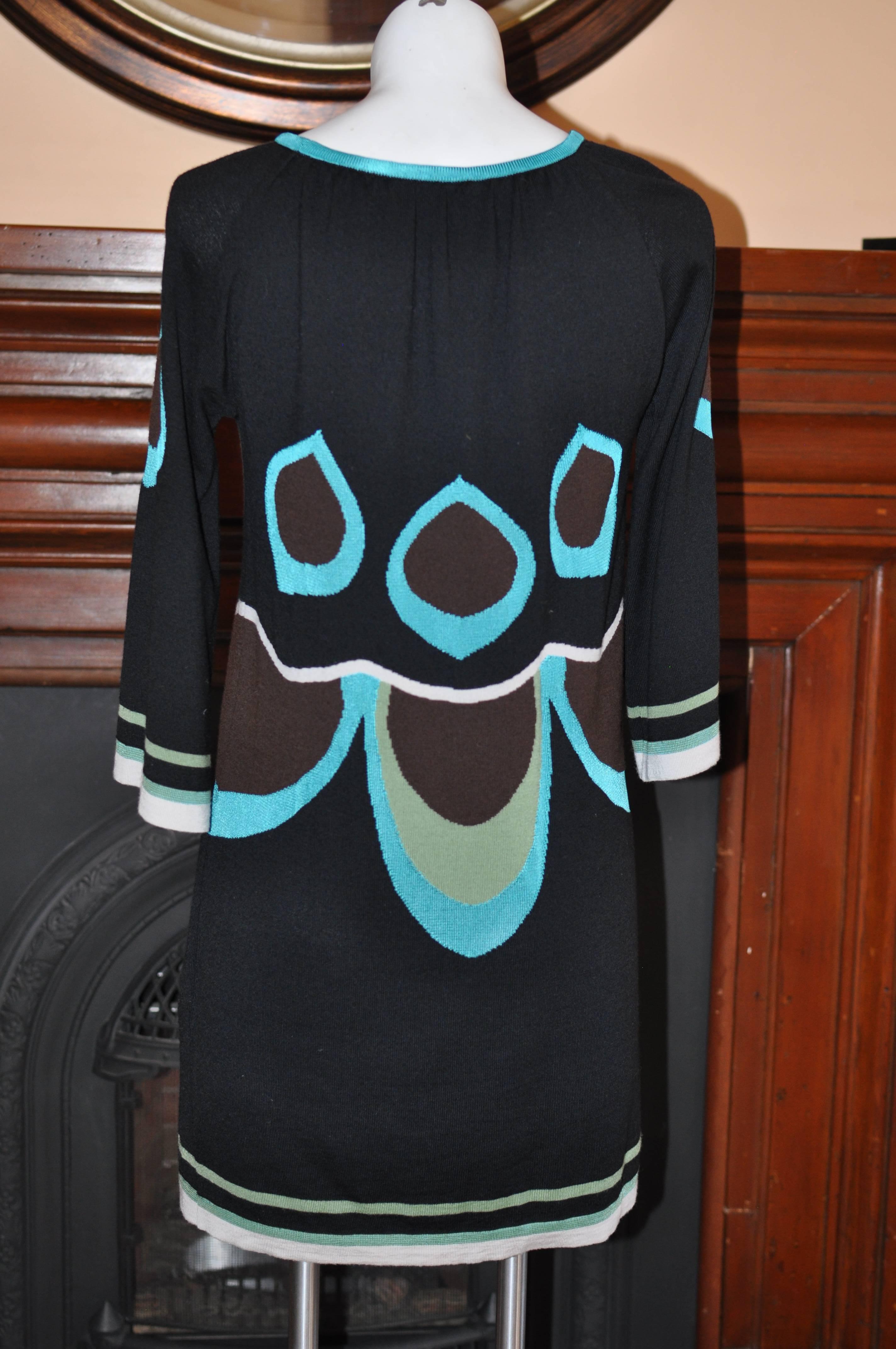 Comfortable fully lined dress with 86% merino wool, 8% viscose and 6% angora; 3/4 wide sleeves and nice op art print. 

Black background with brown, green and off-white.