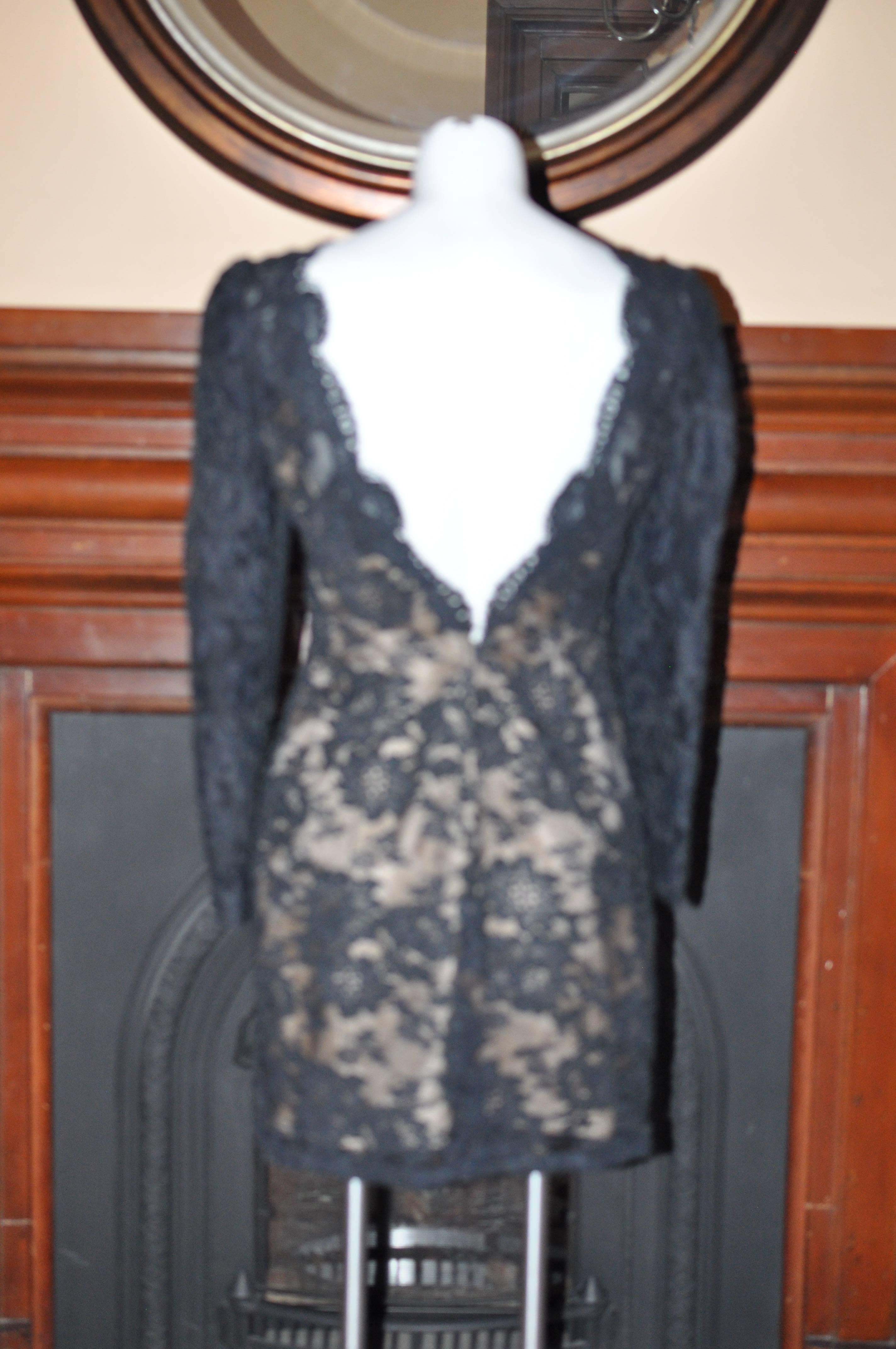 A sophisticated dress made of cotton, nylon and rayon, with a peach colored lining.

Nice heavy lace with a floral pattern and clearly raised borders. The neckline is see-through as are the lined sleeves.

There is a built in bra.