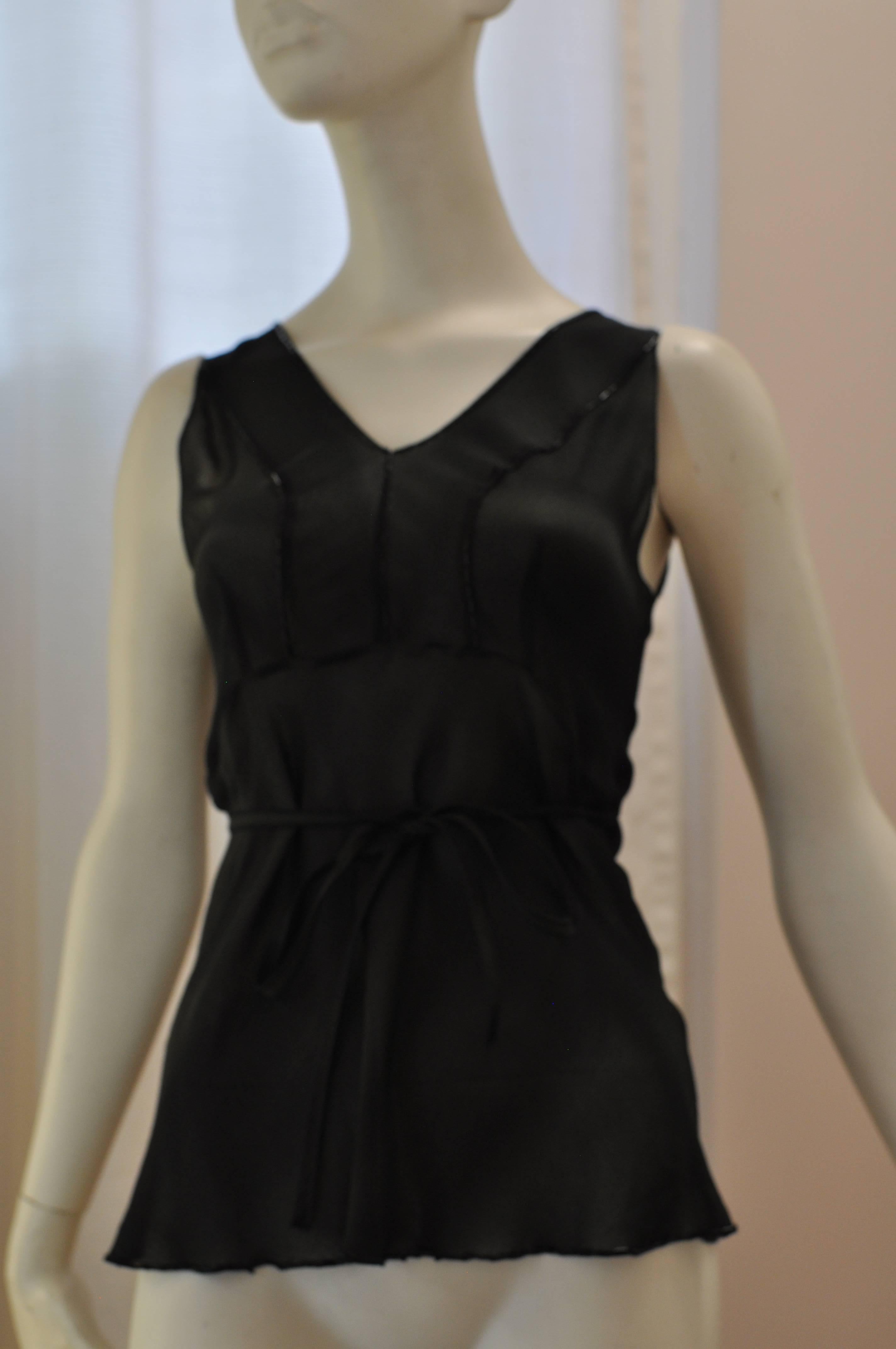 At first glance the color is deceiving, but in the light it is not all black but black and dark green in an assymetrical pattern. The neckline, bodice and hem is beaded and there is an attached thin belt which can be done up at the back or front.  