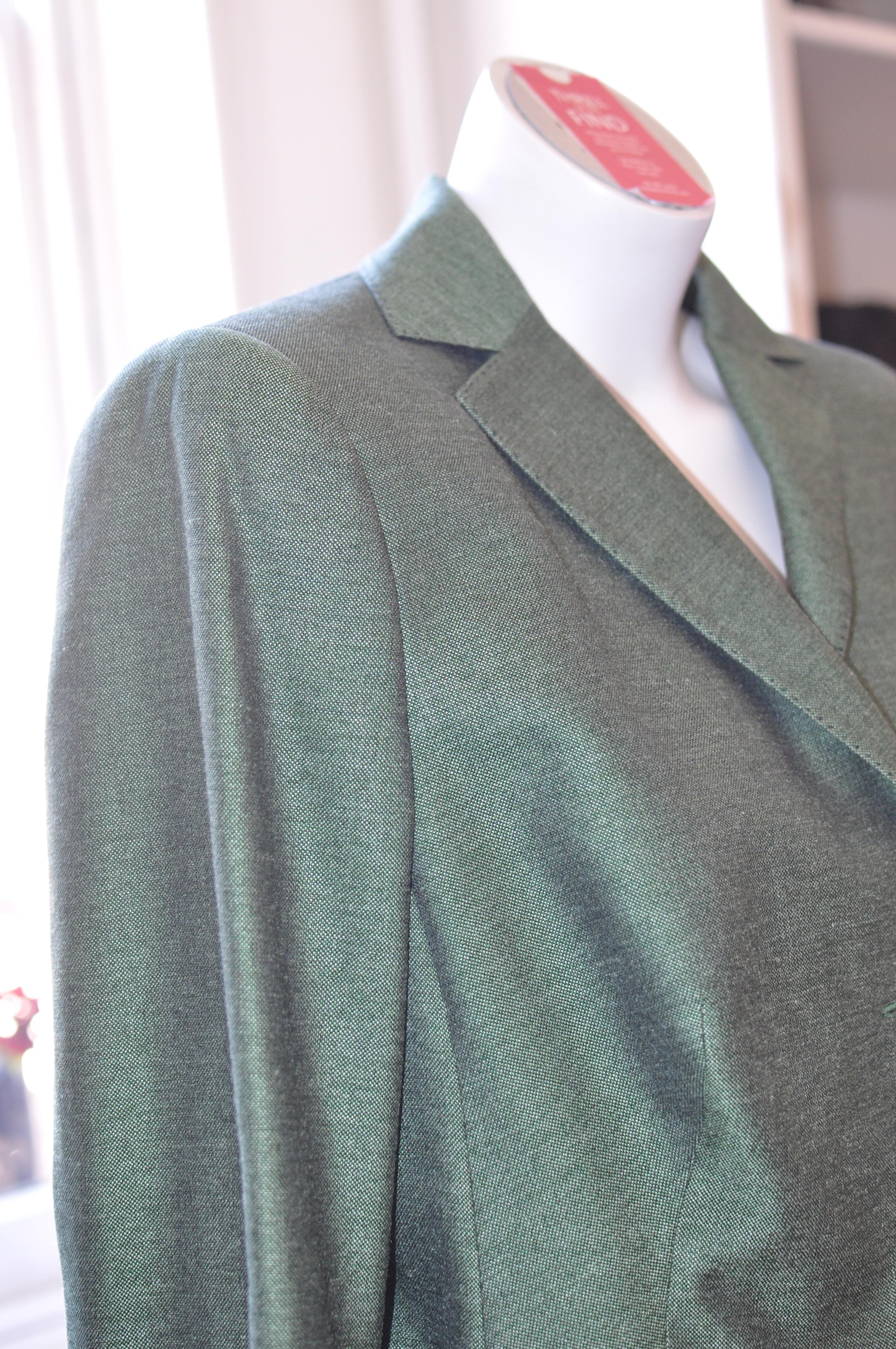 A.K.R.I.S is one of my favorite brands because of the attention to detail in and out and excellent tailoring. This jacket is of a lovely green silk weave with one patch pocket at the bust and two below the waist. Each cuff has two buttons, in