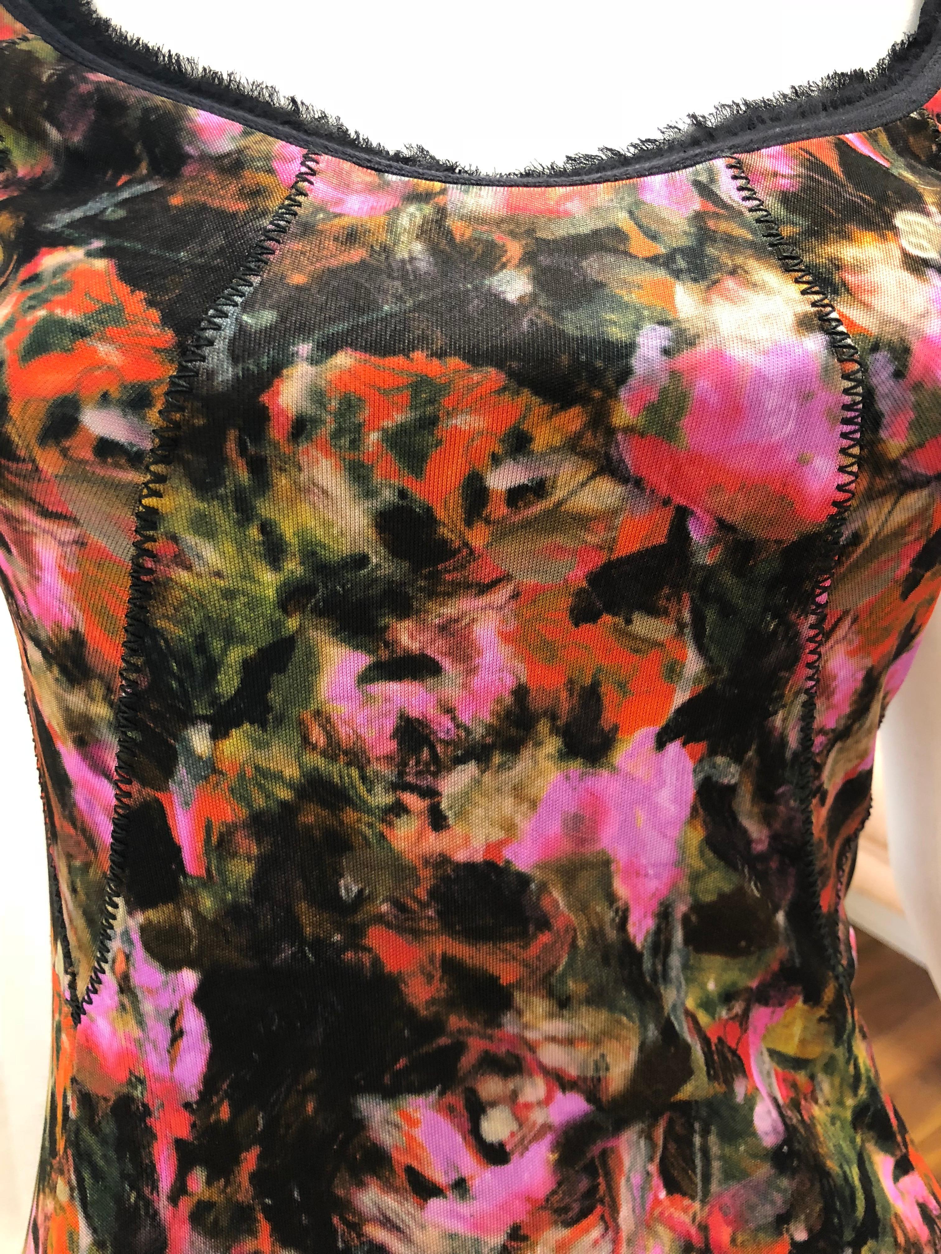 As worn by Jennifer Garner at a Save the Children Event. This floral dress has black feathery chiffon trim on the neckline and around the short sleeves.  There is a zig zag detail on the top part of the dress which is replicated on the hem, and the
