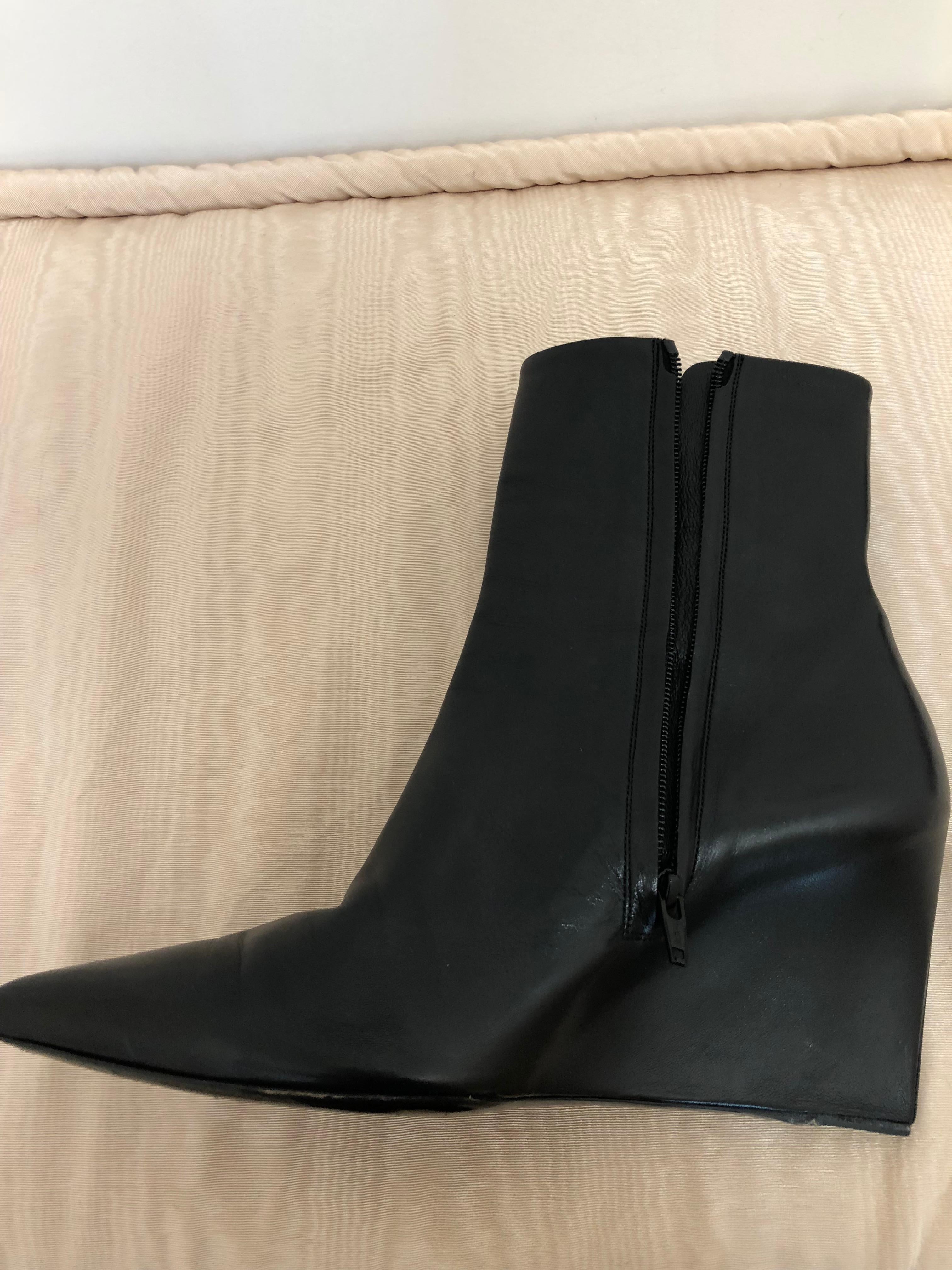 These Balenciaga black leather wedges are beautifully crafted of a single layer which encases both the upper and heel. This is a gorgeous and very sleek pair of booties with a pointed top and side zip closure.  We believe they are from the 2015
