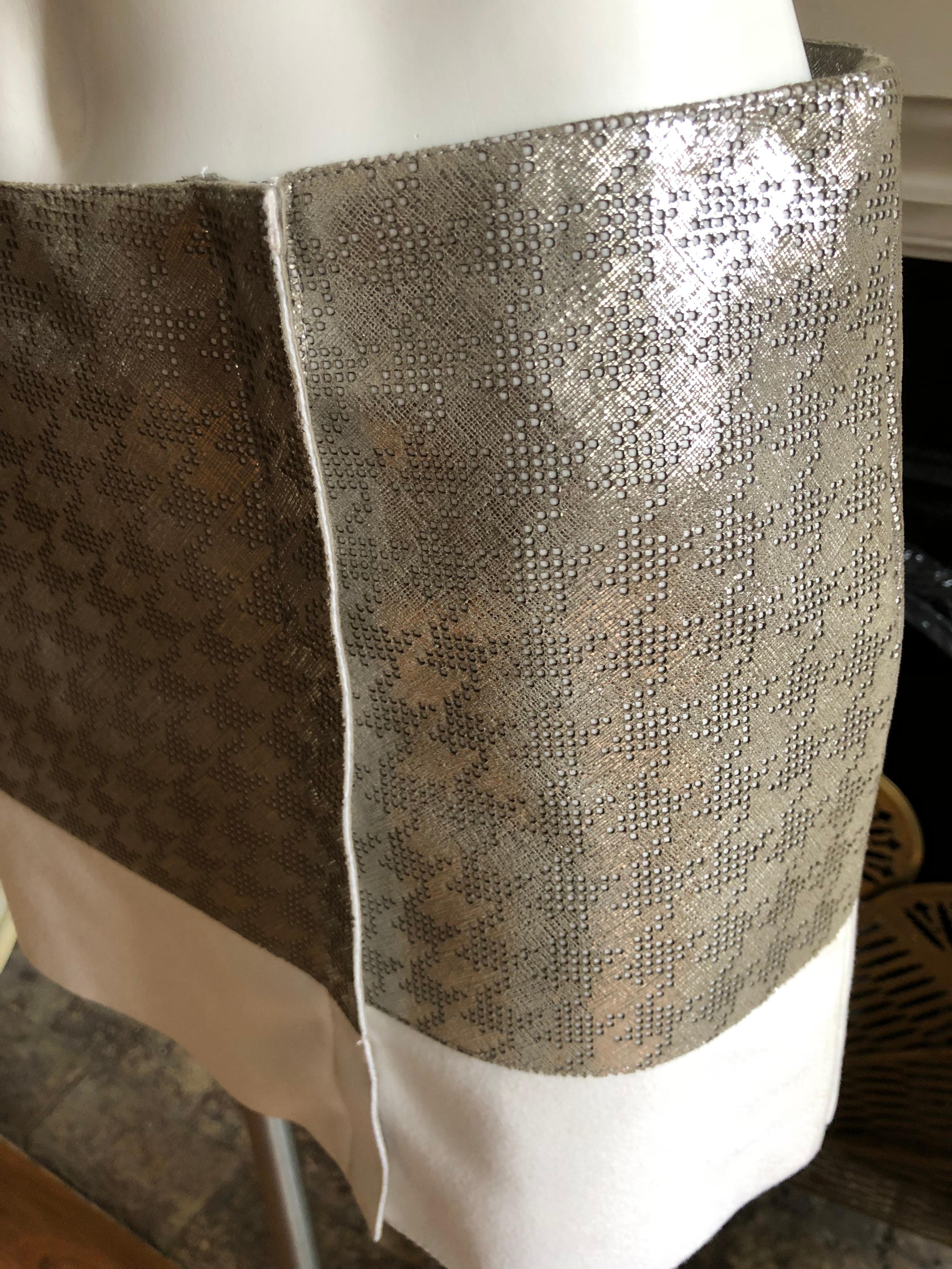 Wonderful patterned leather which looks like a braille in silver metallic leather with a white felt wool hem. The waist measurement is 31