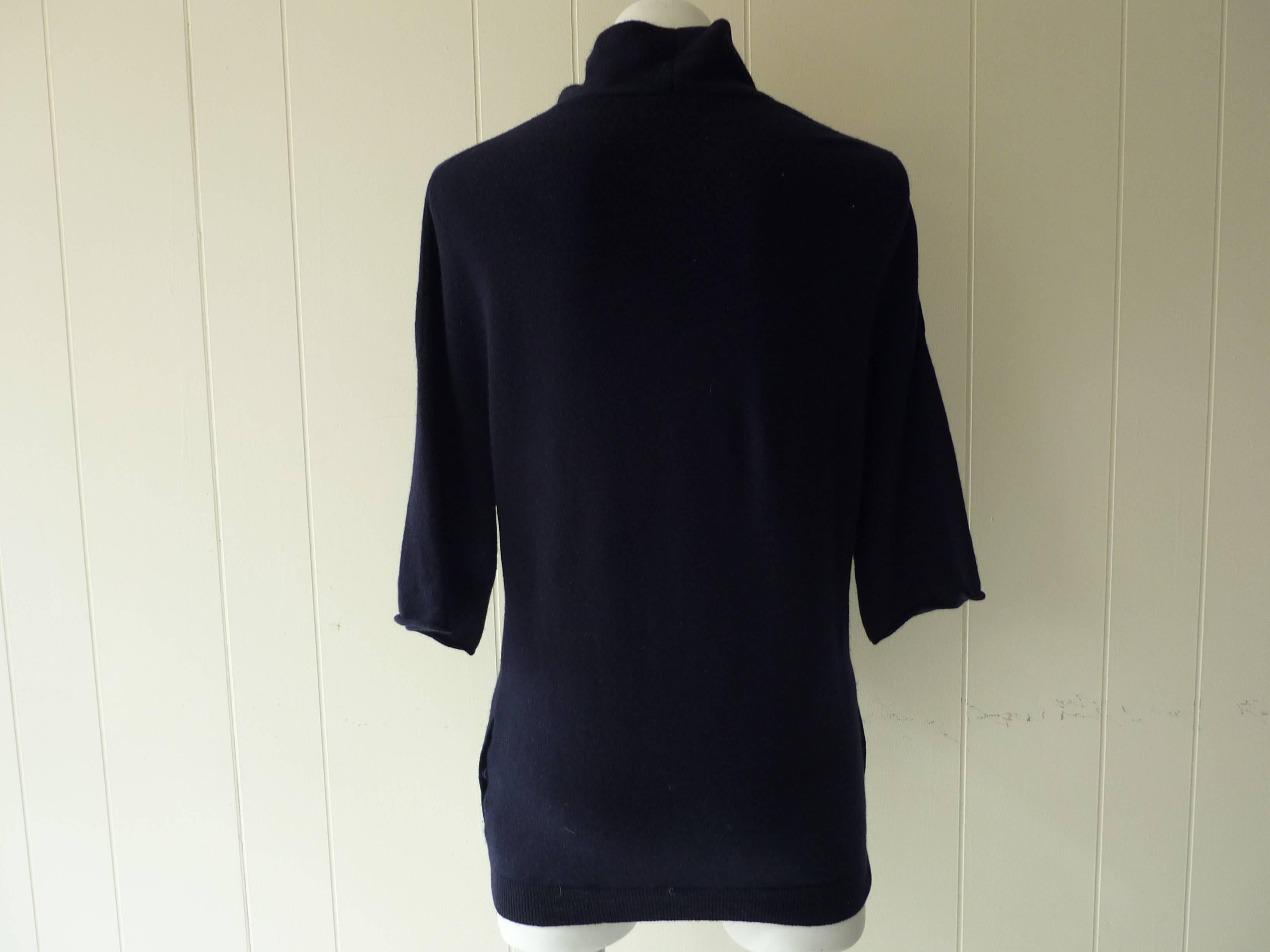 Beautiful quality cashmere, this sweater adjustable bow details, raglan below the elbow sleeves and two slant pockets with snap closure. This is a tunic lenght sweater.