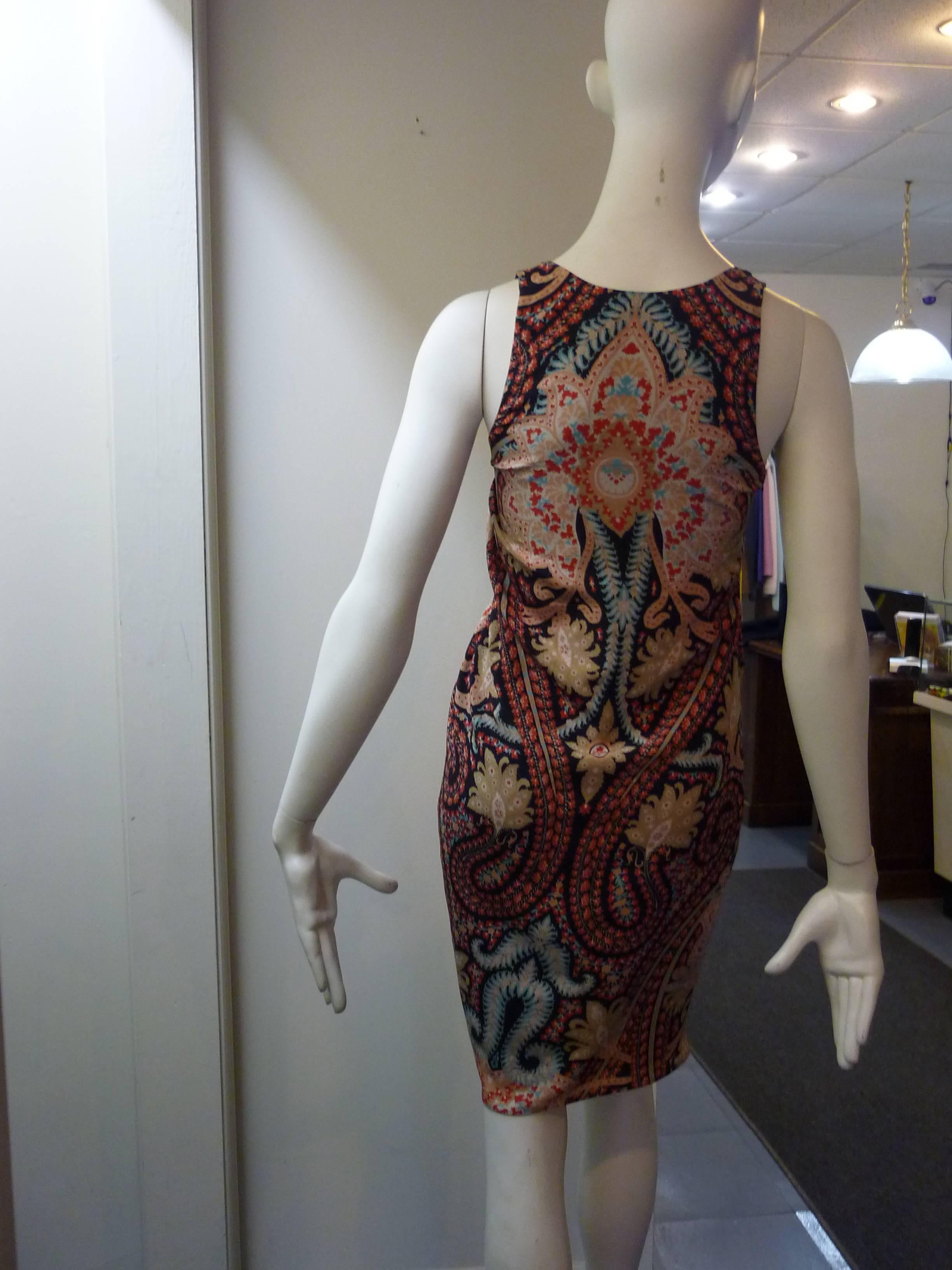 This multicolored paisley print crepe de chine silk dress has a scoop neck and slight racer back. There is an asymmetrical pleated twist detail at the waist, and closure is a side zipper. The lining is also silk.